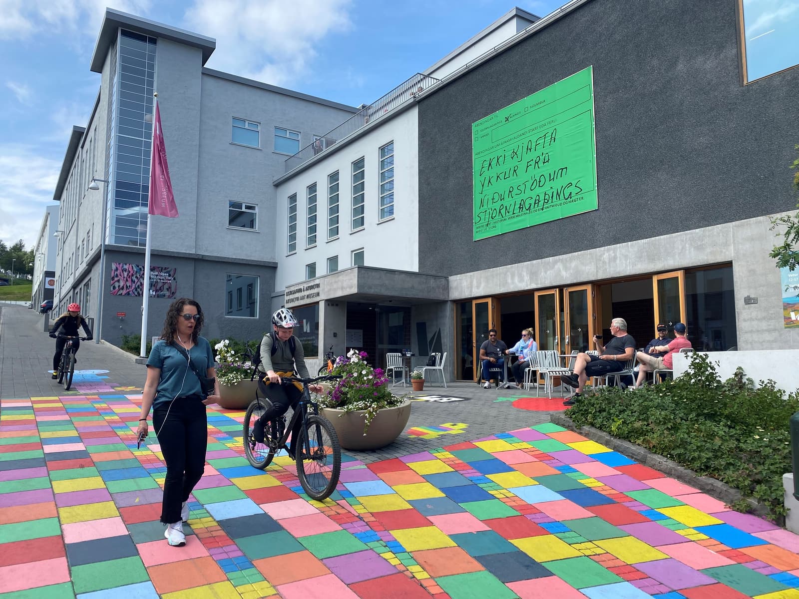 Akureyri Art Museum exterior in Listagil with colorful paving and people outside the entrance.
