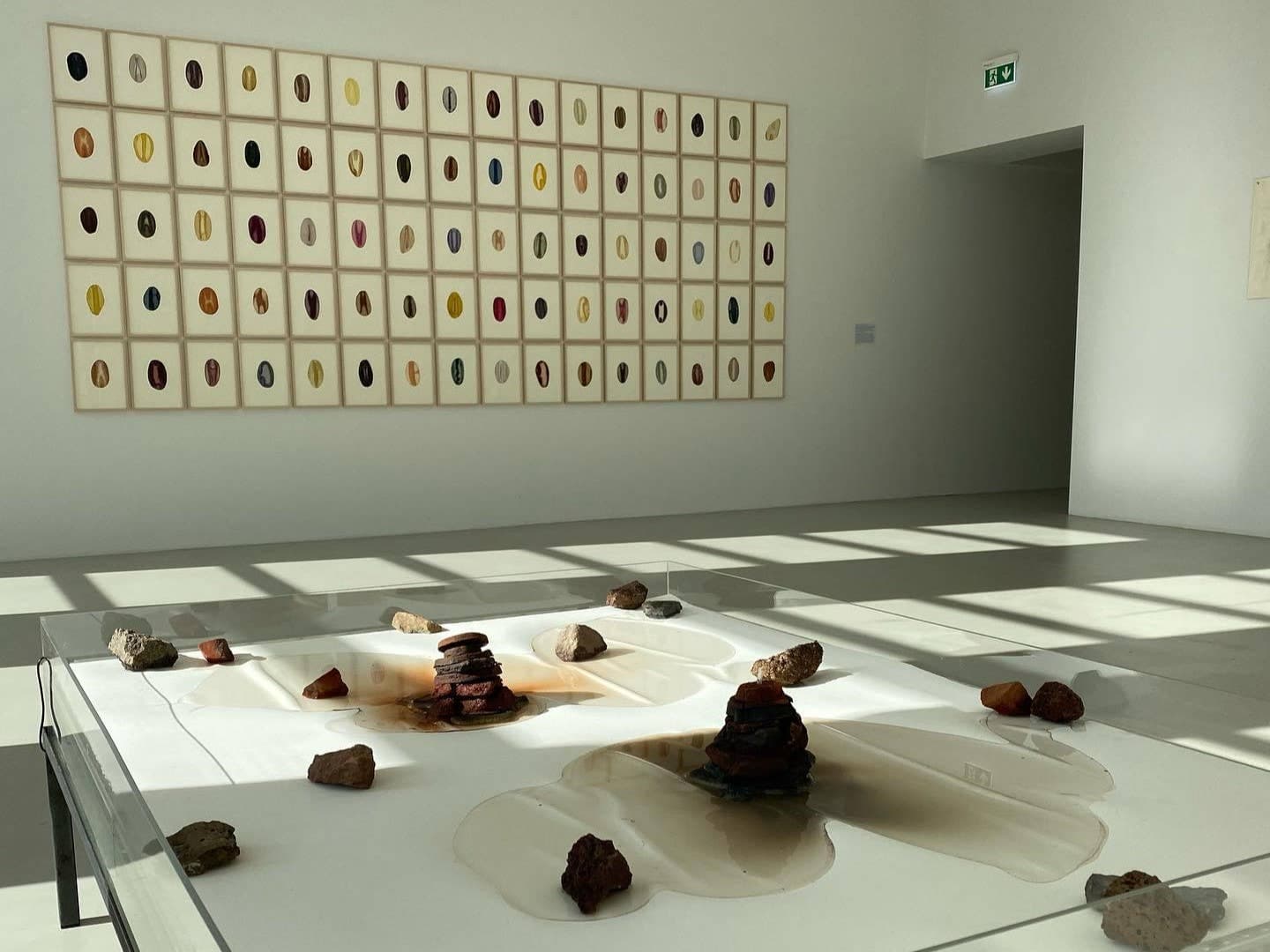 Bright gallery installation inside Akureyri Art Museum with objects and framed works.