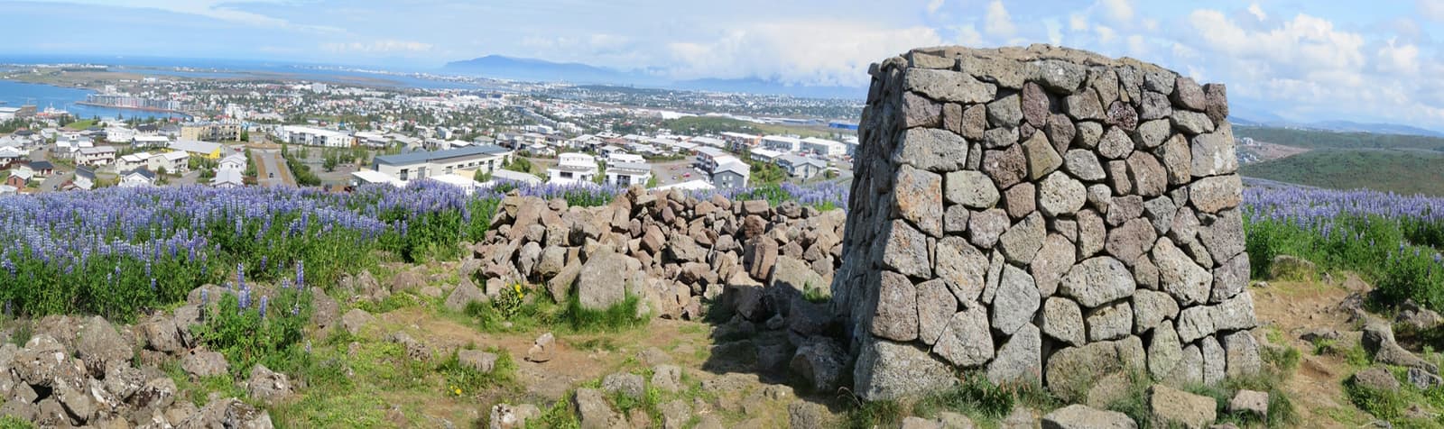 Wide Ástjörn and Ásfjall landscape near Hafnarfjörður with low hills and lake-area greenery.