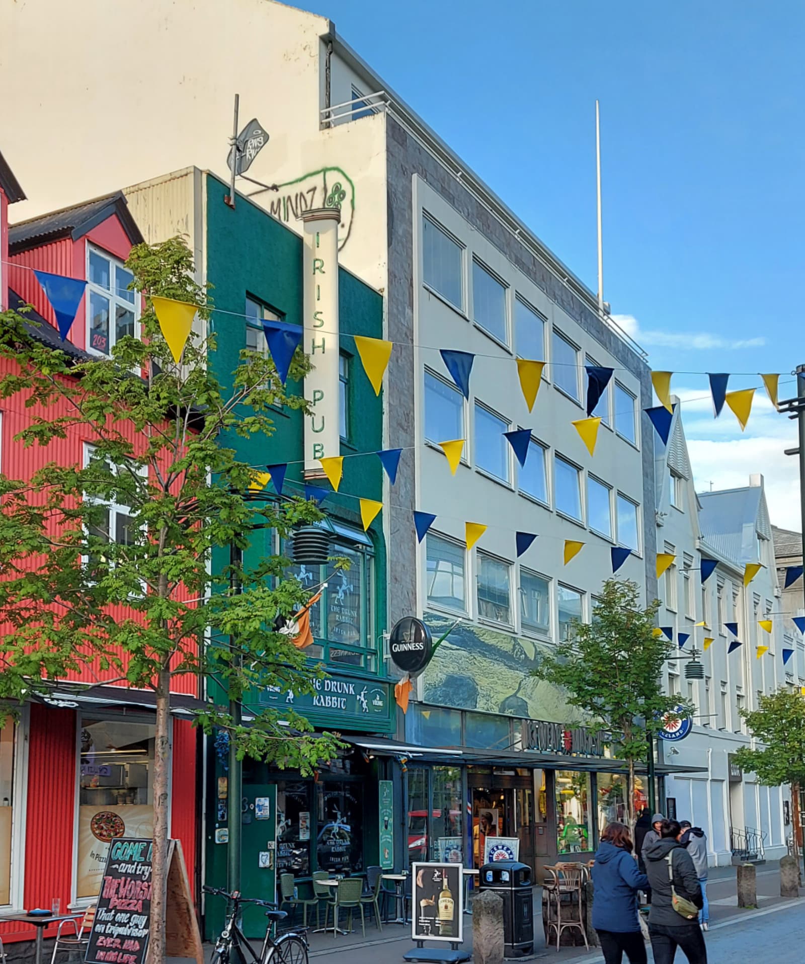 Colorful Austurstræti storefronts and flags in downtown Reykjavík.