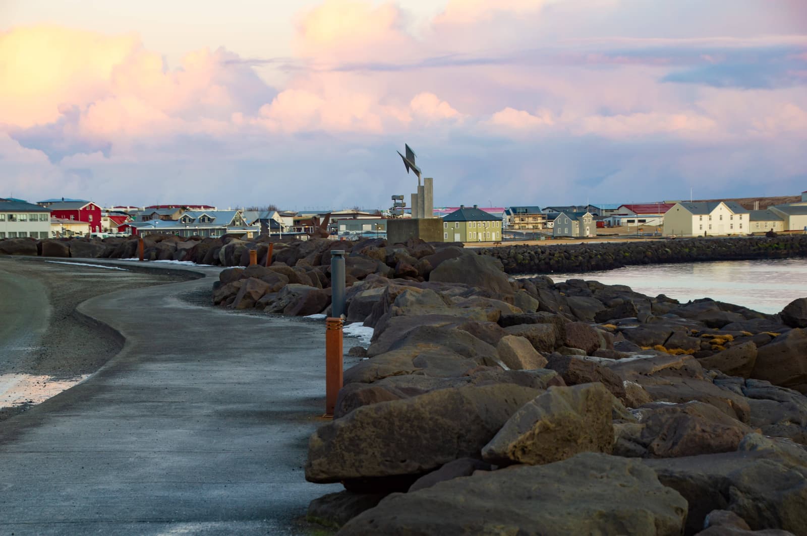 Coastal path and volcanic rock shoreline near Keflavík harbor.