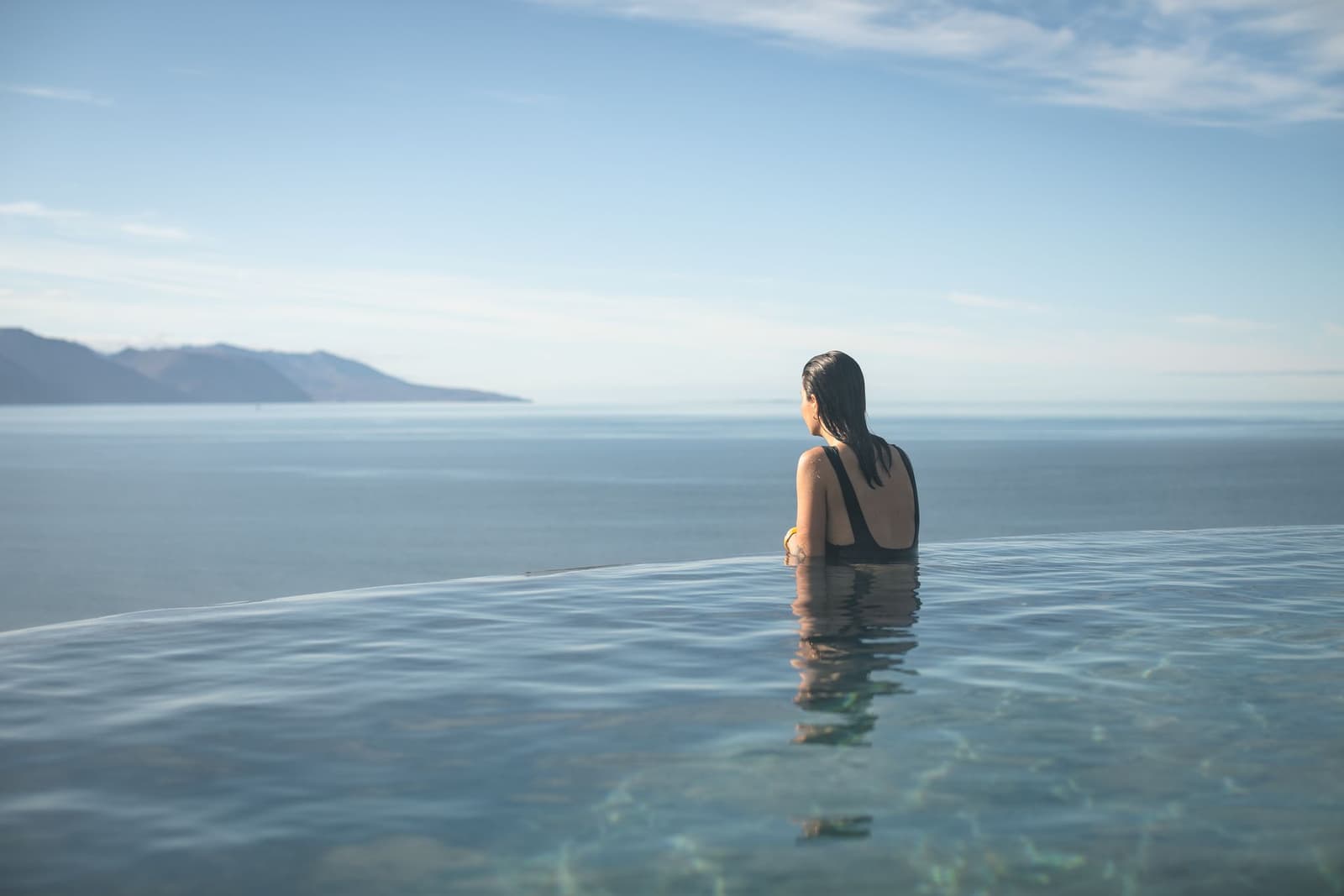 GeoSea pool edge with warm seawater looking across Skjálfandi Bay in North Iceland.