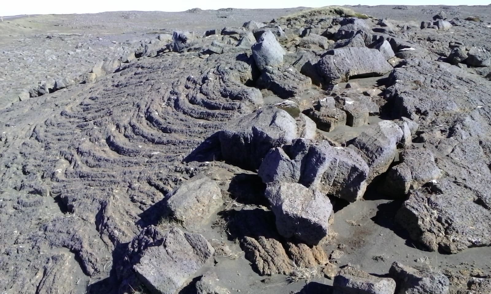 Layered volcanic rock near Hafnaberg with low Reykjanes terrain beyond.