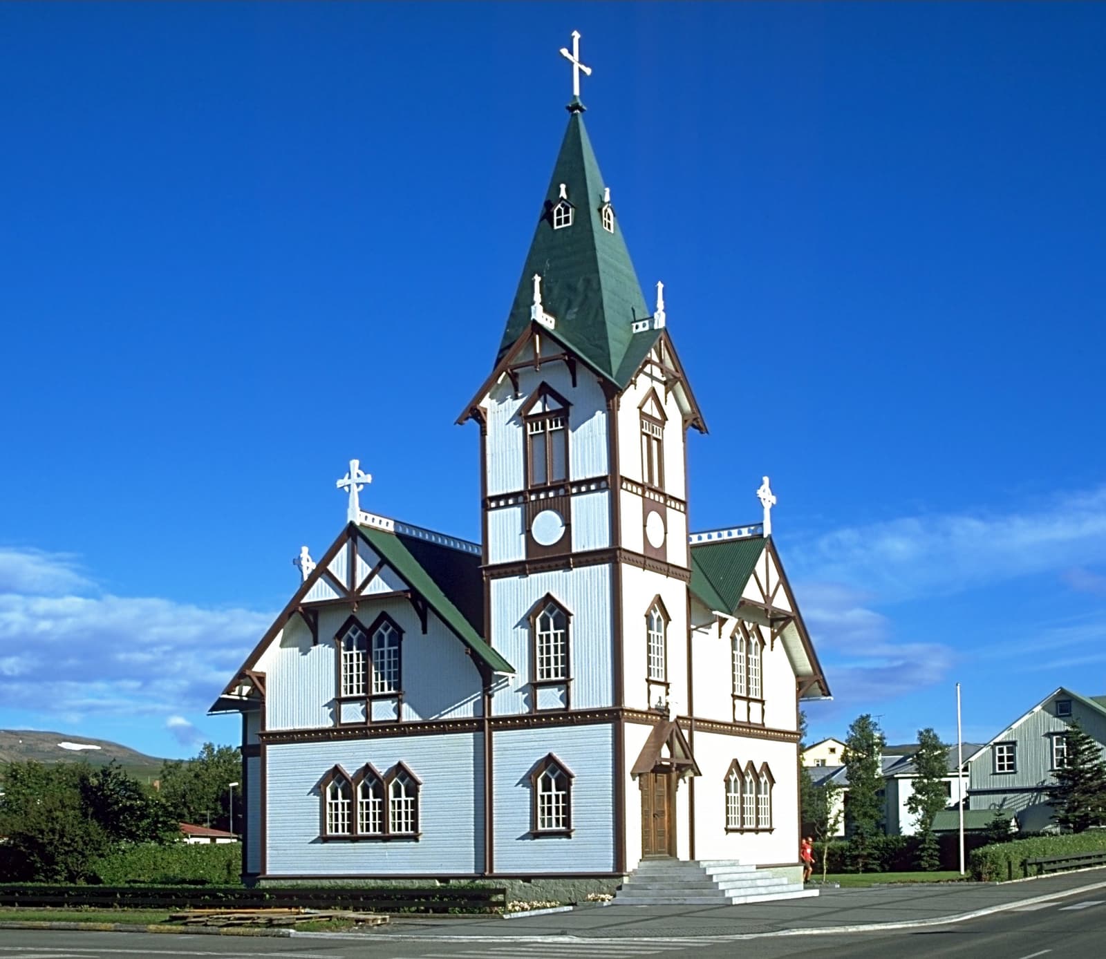 Húsavíkurkirkja wooden church with white walls and red trim in the center of Húsavík.