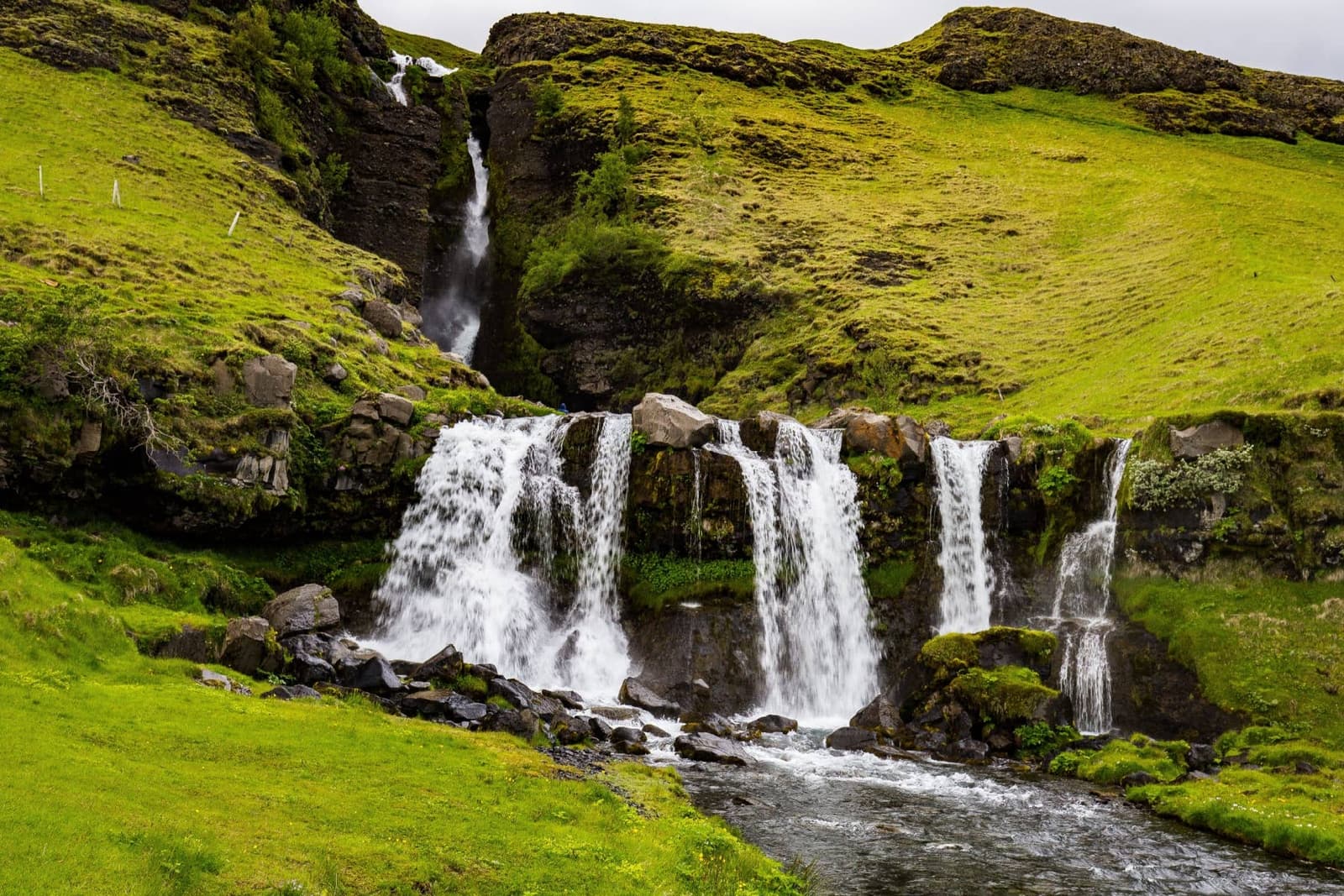 Twin cascades of Gluggafoss in green hills east of Hvolsvollur.