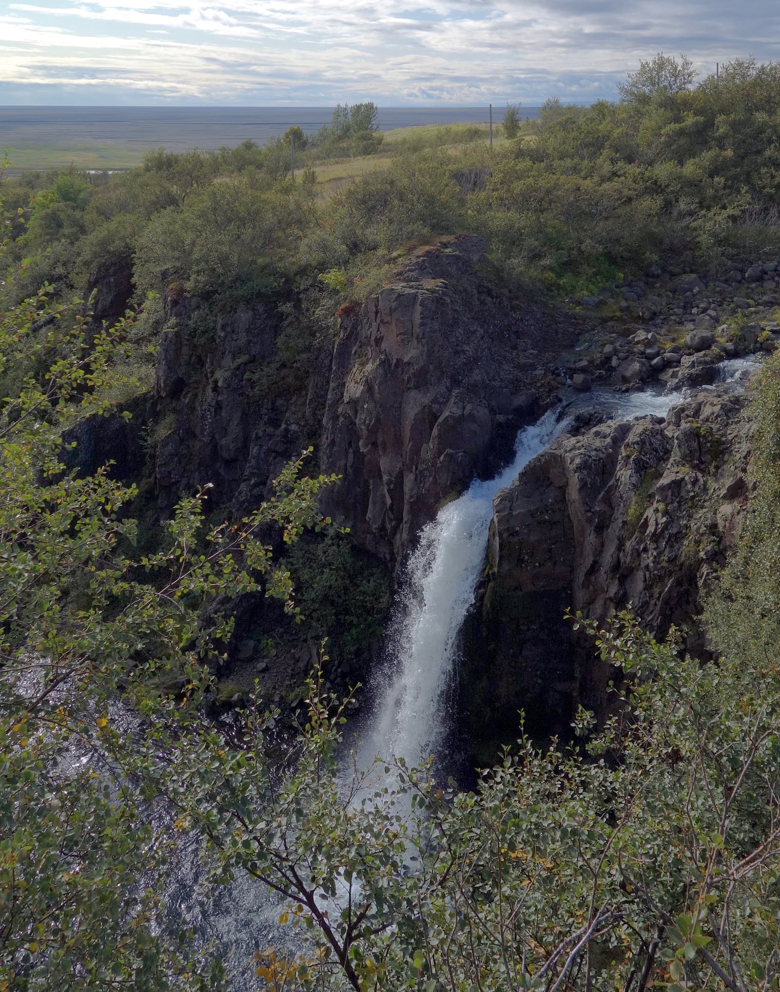 Magnúsarfoss dropping through a narrow green Skaftafell gorge.
