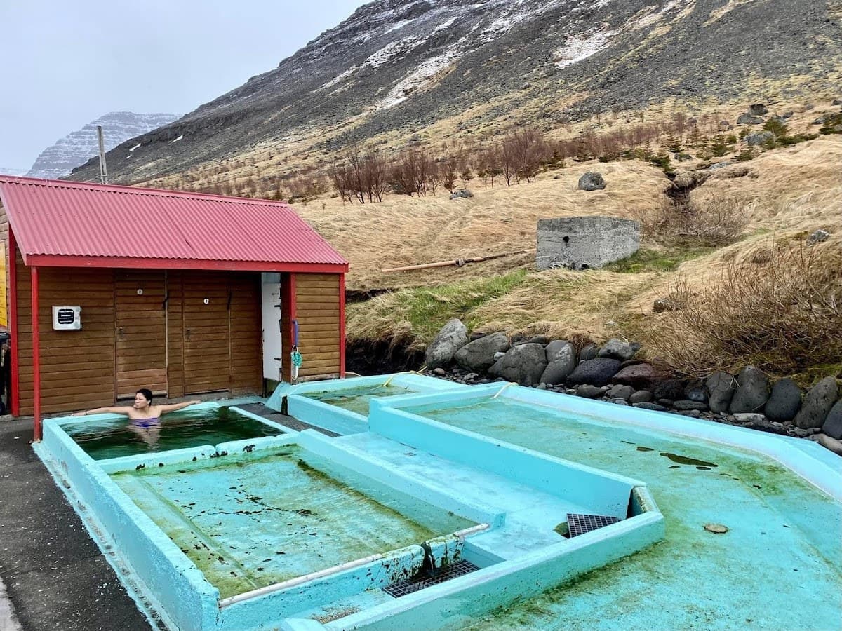 Pollurinn hot pools with the hillside and Westfjords landscape around Tálknafjörður.