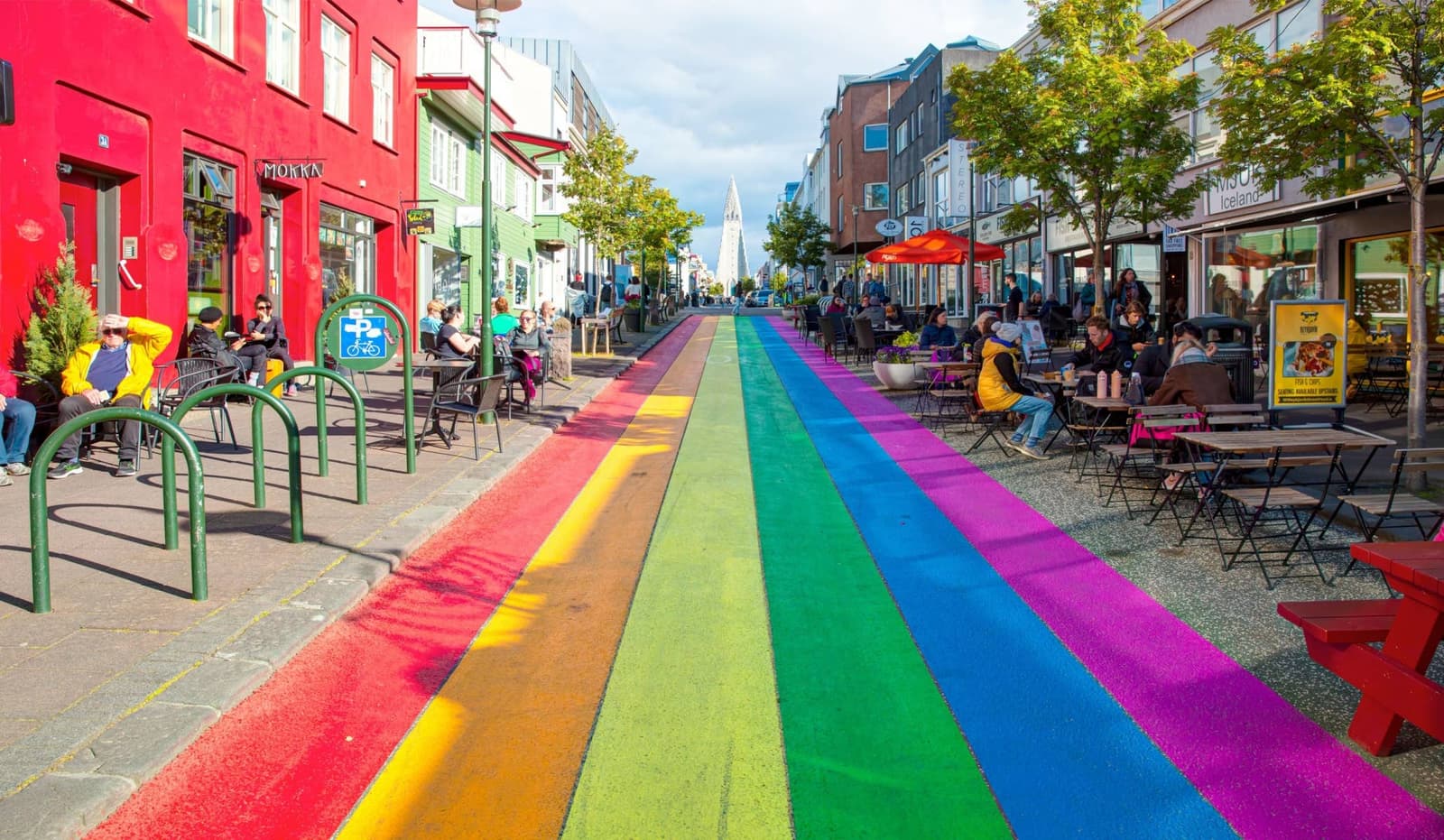 Outdoor seating beside the rainbow-painted Skólavörðustígur street in Reykjavík.