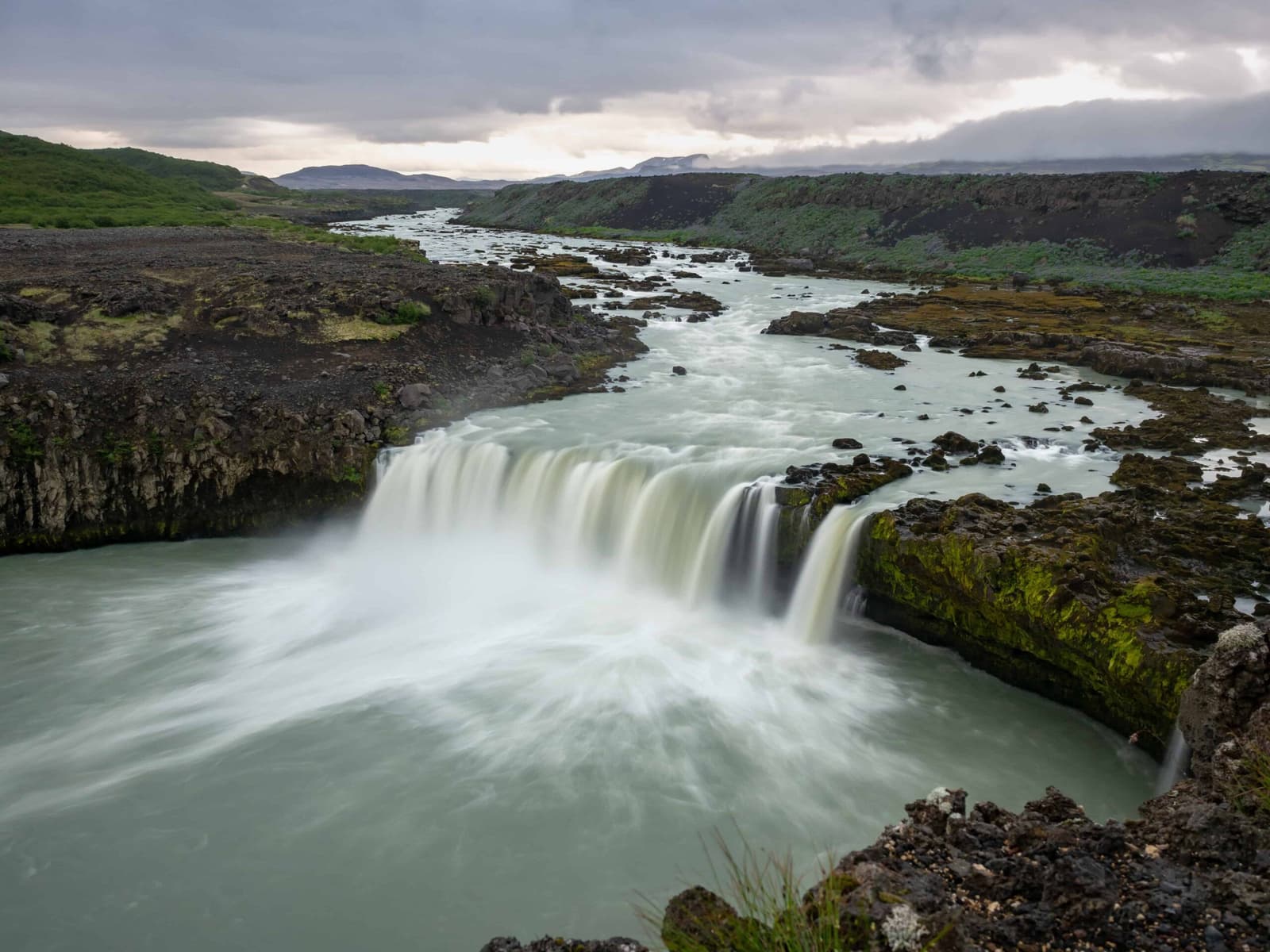 Þjófafoss dropping into a blue-green pool among dark lava beside the Þjórsá river.