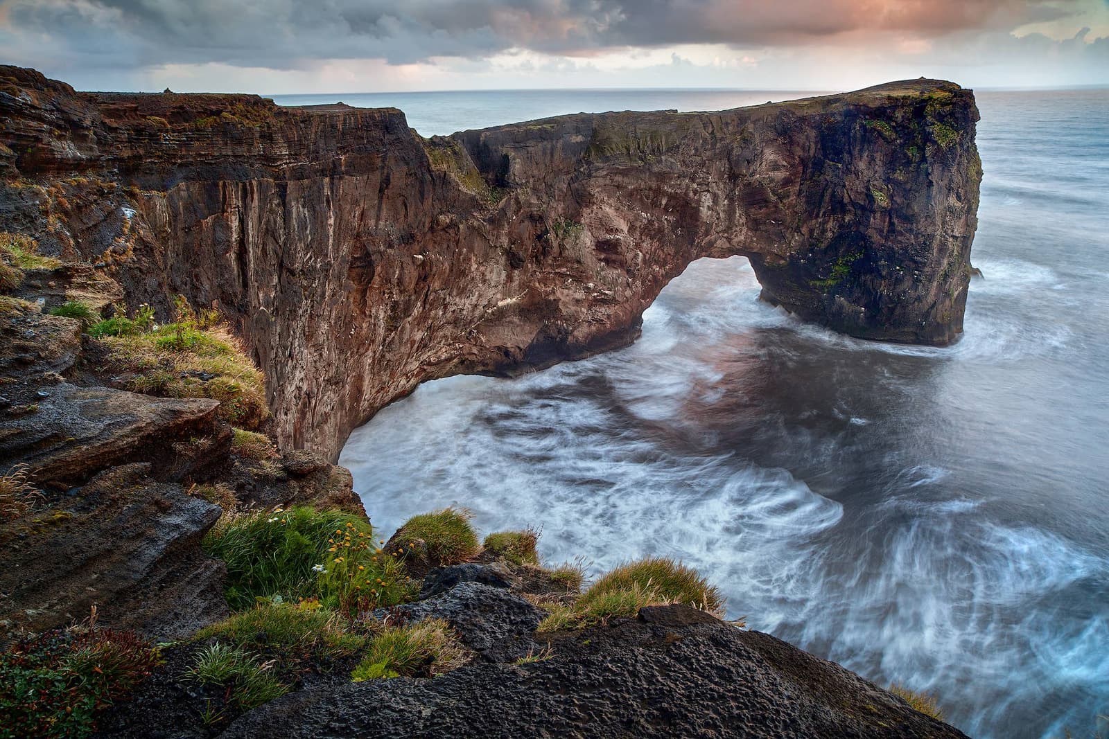 Dyrhólaey sea arch and surf on the coast west of Vík.