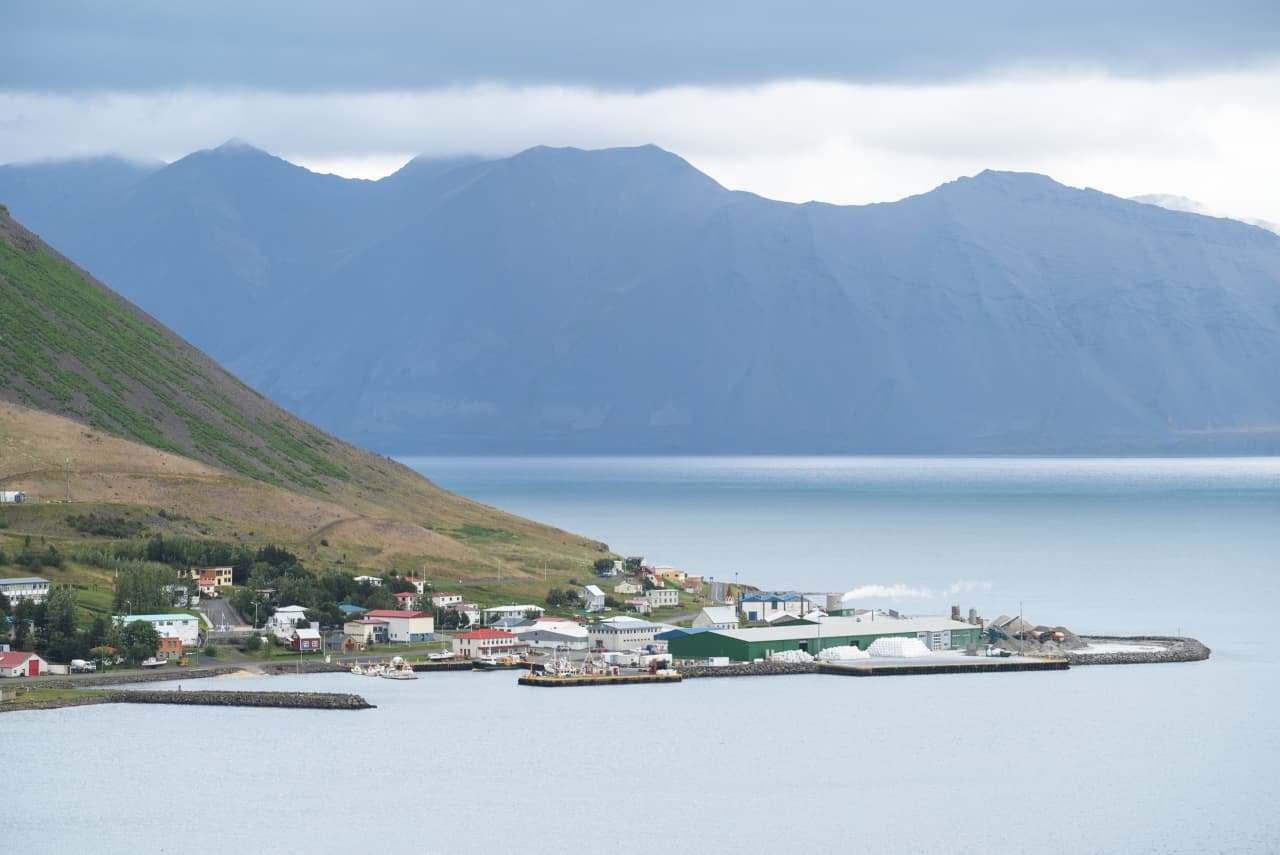 Bíldudalur harbor and village beneath blue Westfjords mountains beside Arnarfjörður.