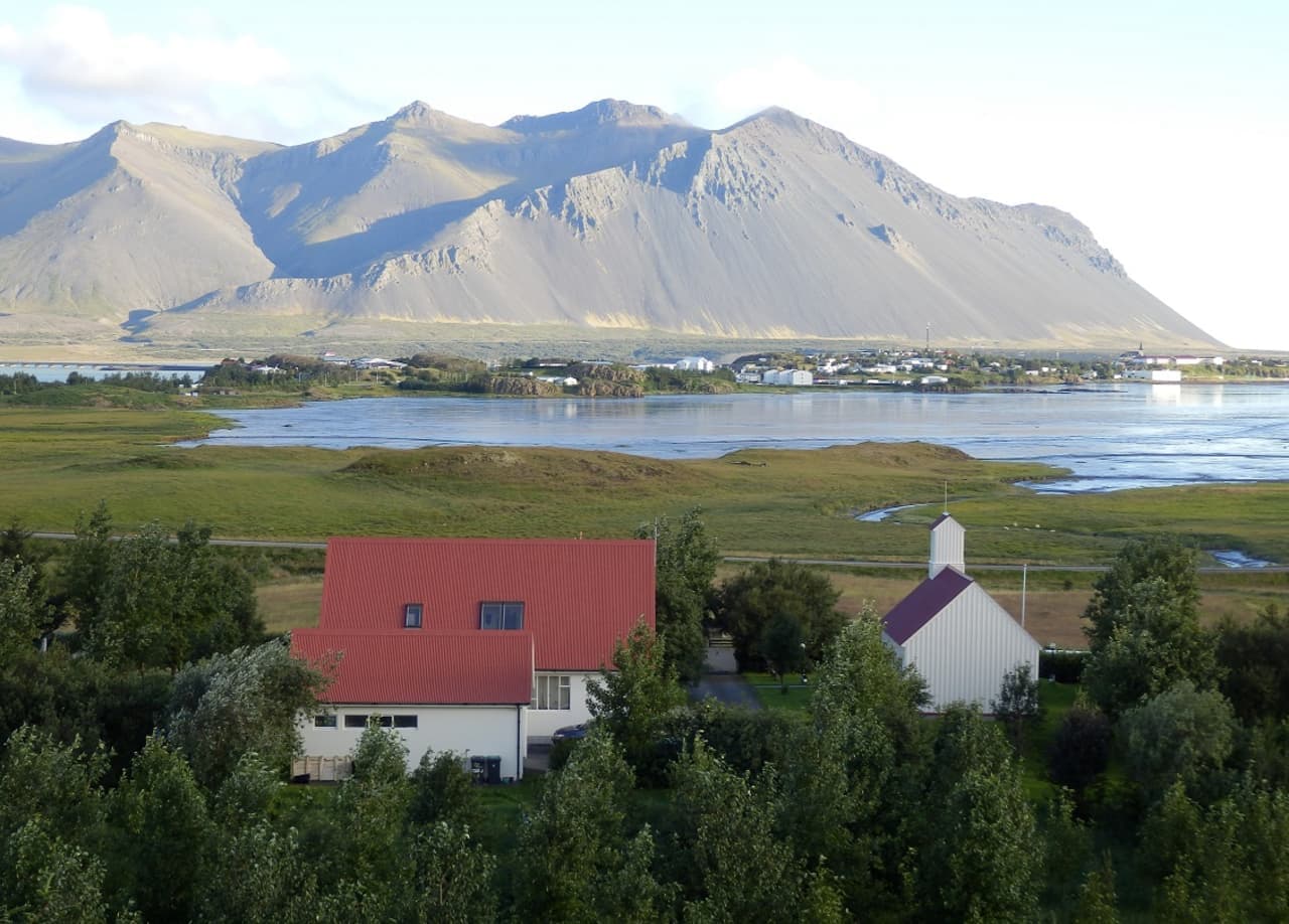 Borg á Mýrum church and farm buildings below mountains across Borgarnes and Borgarfjörður