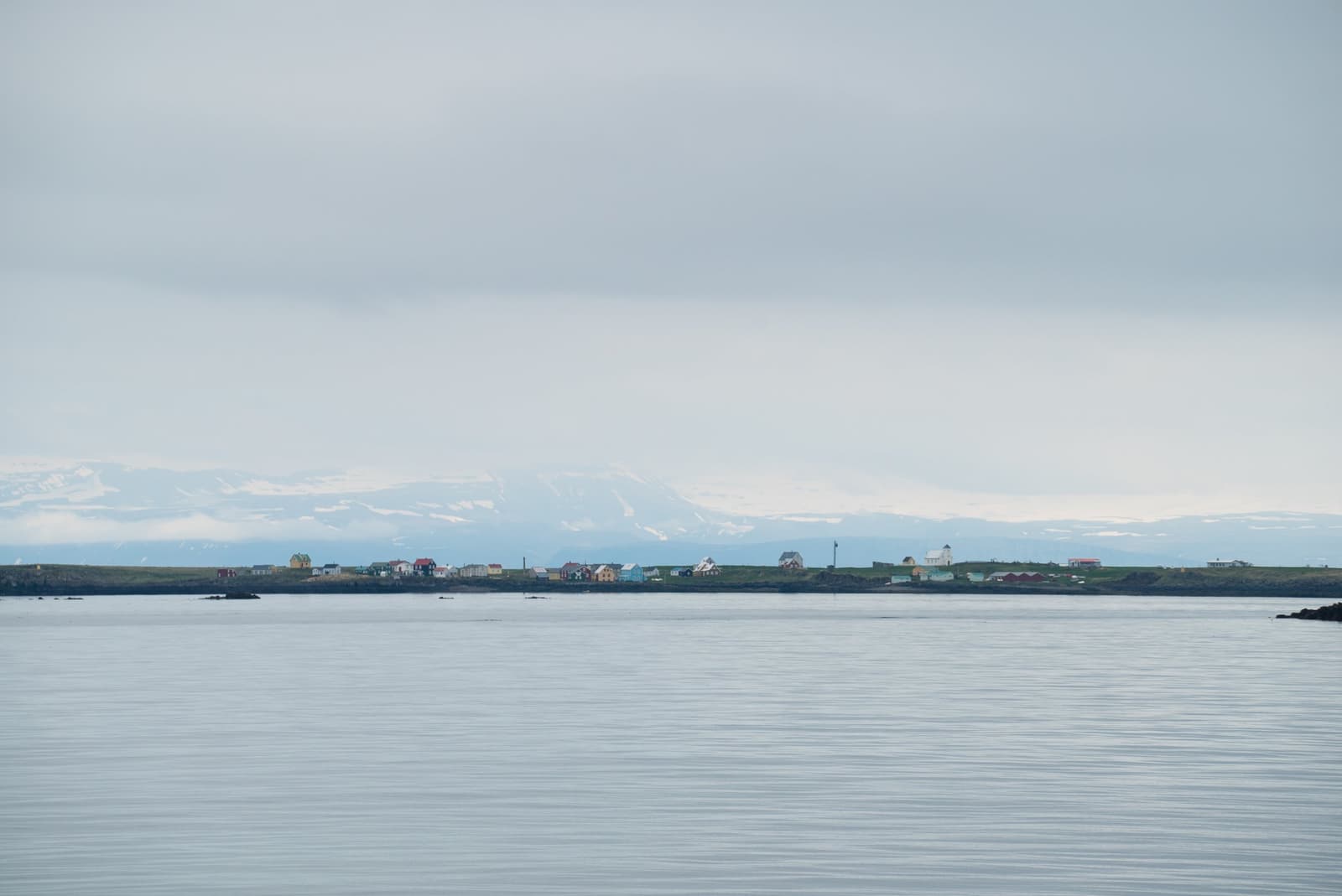 Flatey village and the water of Breiðafjörður below pale mountains.
