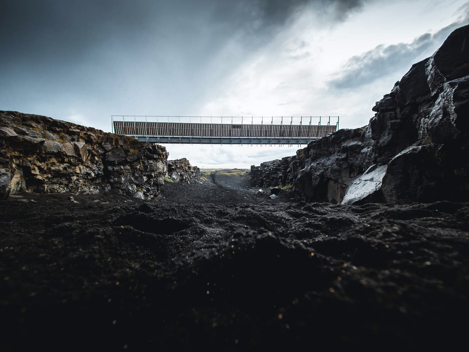 Low view through the dark fissure below Bridge Between Continents in Reykjanes.