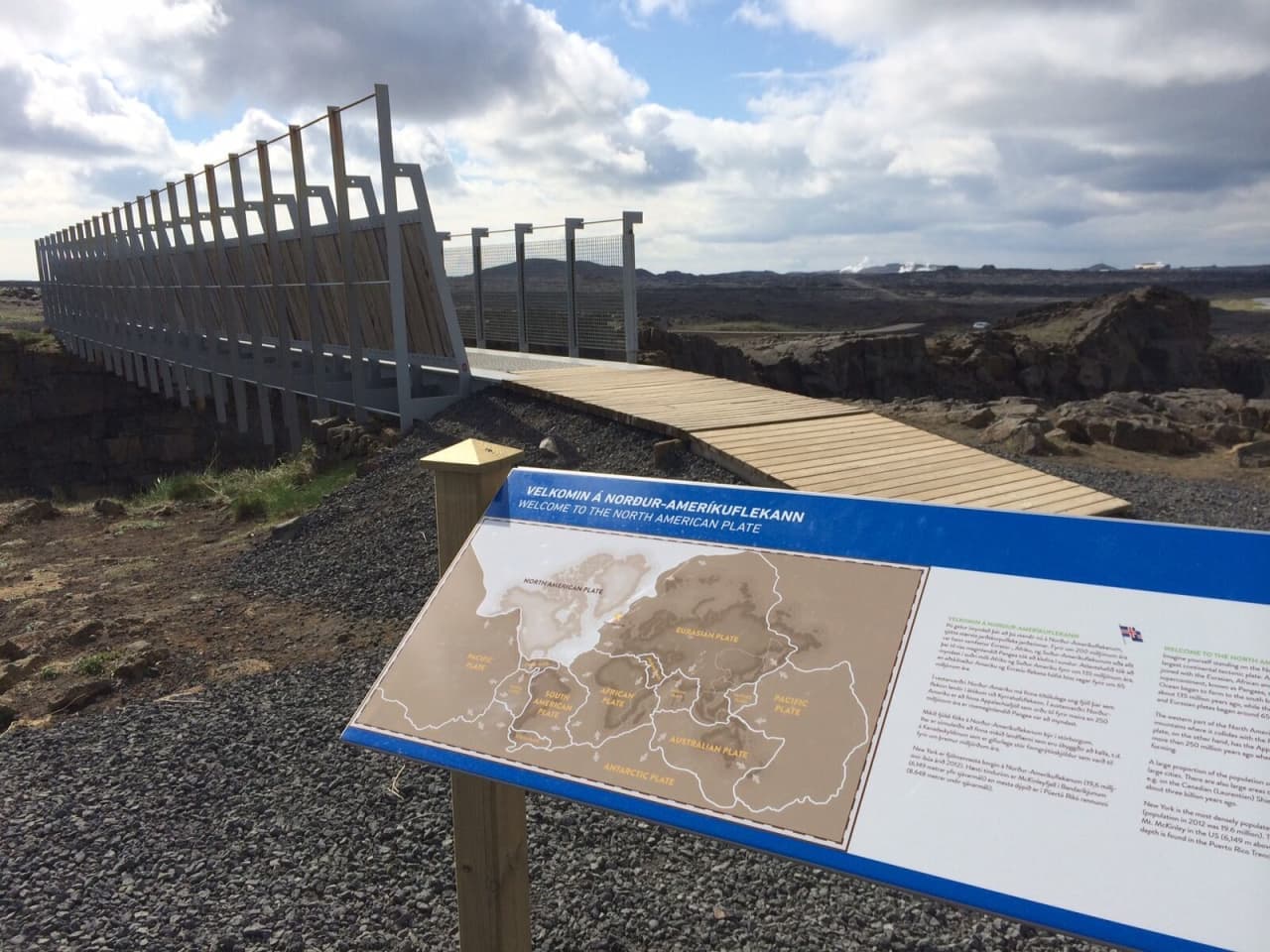 Information sign and walkway leading onto Bridge Between Continents in the Reykjanes lava landscape.