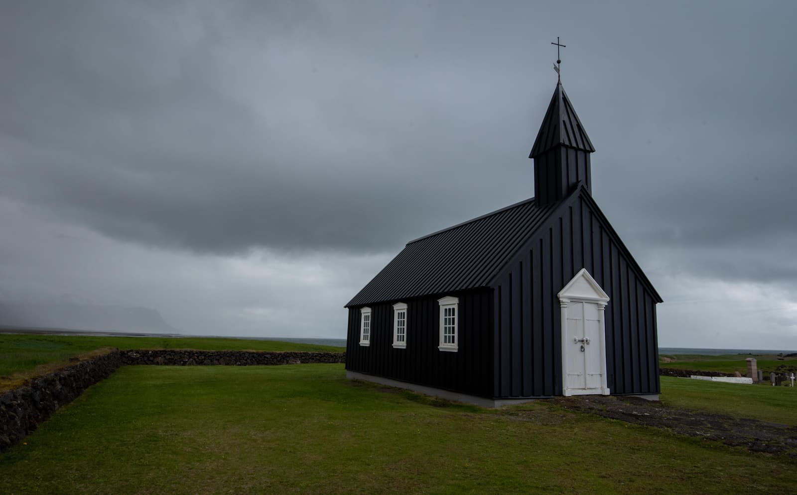 Búðakirkja black church at Búðir with open Snæfellsnes landscape behind it.