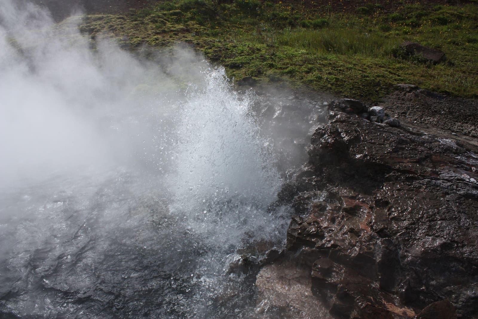 Boiling water and steam rising from Deildartunguhver hot spring in West Iceland.