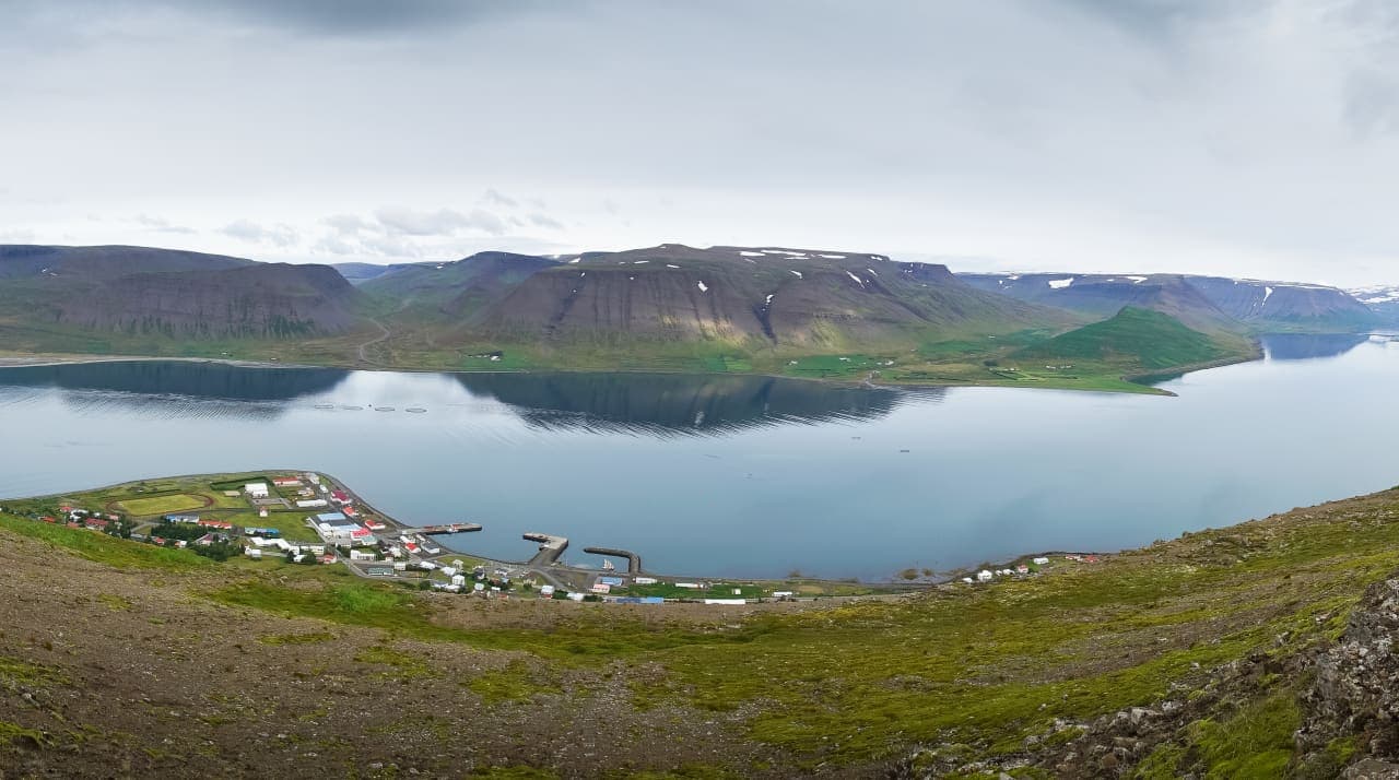 Þingeyri village beside Dýrafjörður with steep Westfjords mountains across the water.
