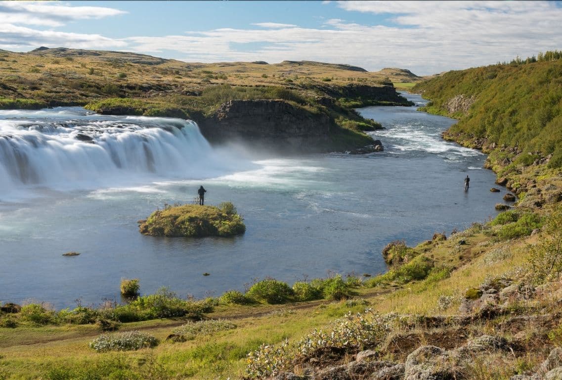 Faxi Waterfall and Tungufljót riverbank with people near the water in South Iceland.
