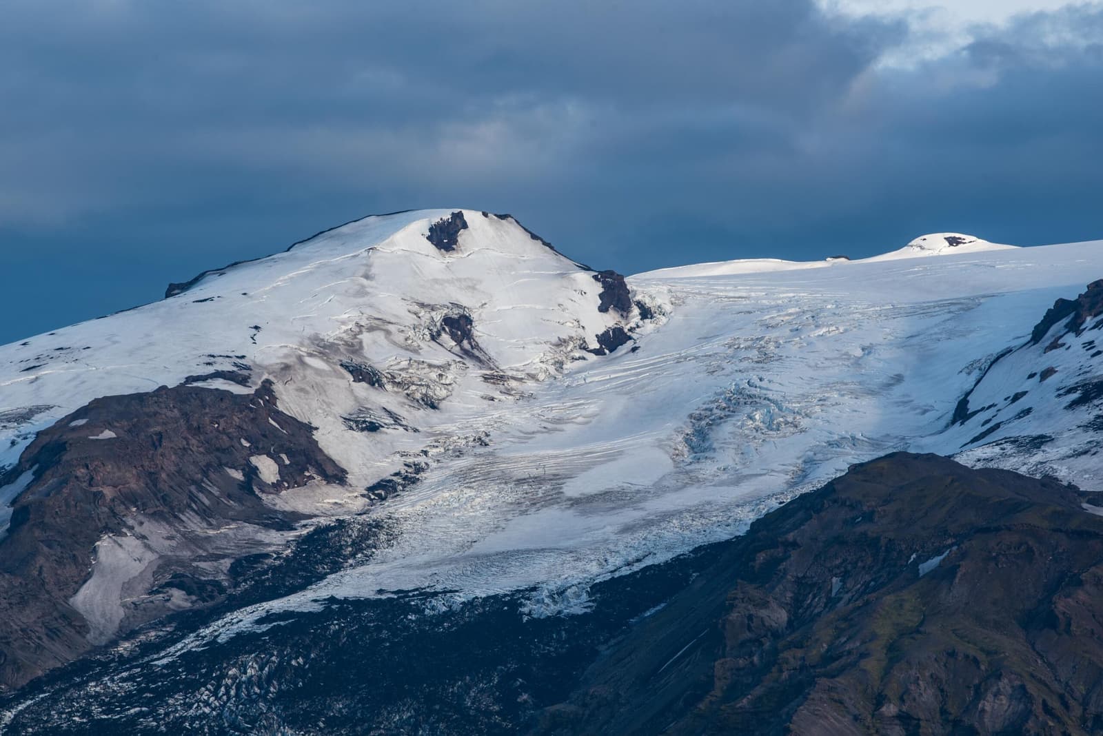 Gígjökull outlet glacier descending from Eyjafjallajökull between dark volcanic ridges.