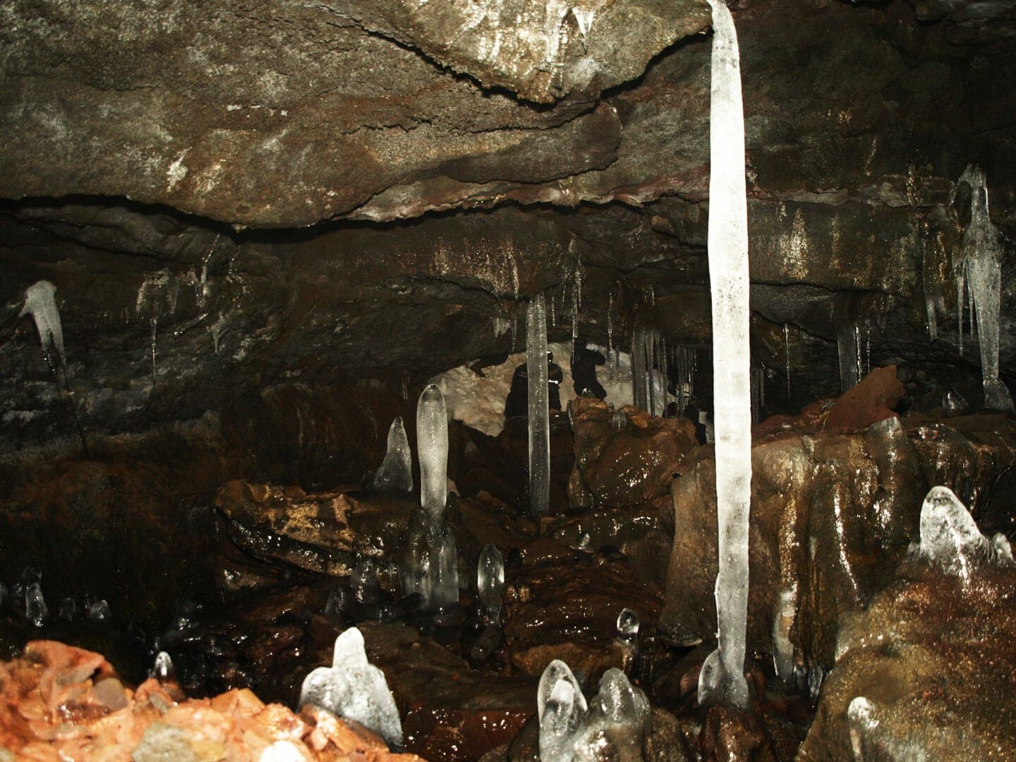 Ice columns and dark wet lava formations inside Gjábakkahellir cave.