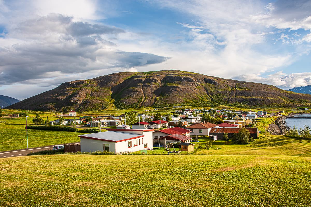 Grenivík harbor and boats with the village and mountain slopes behind.