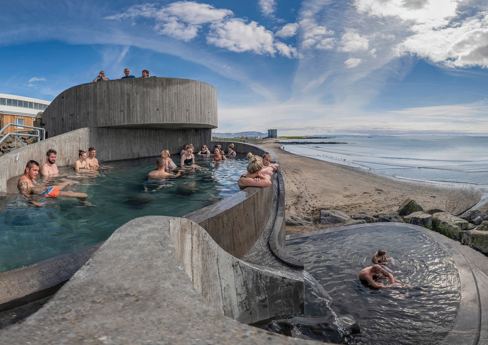 Bathing levels at Guðlaug with Langisandur beach and Faxaflói beyond.