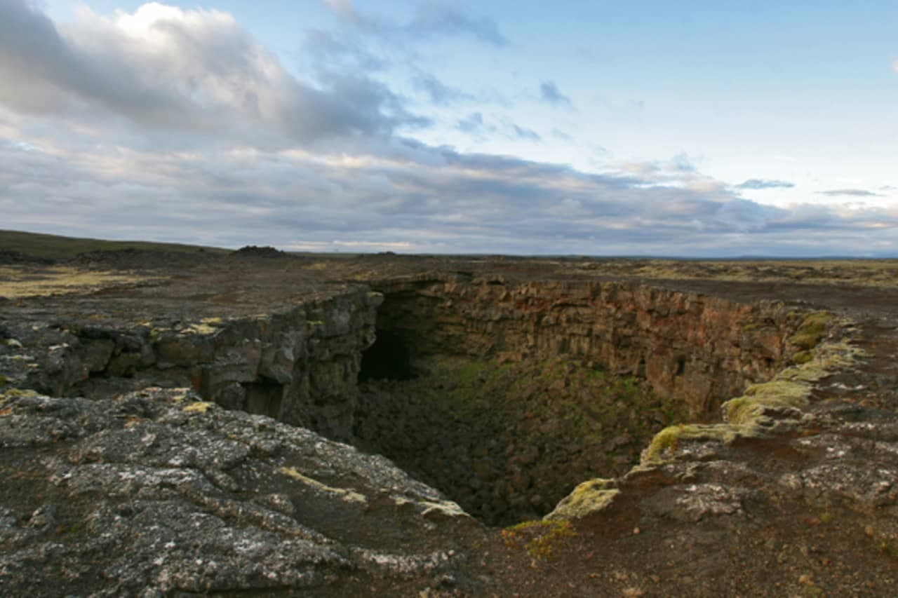 Cave opening and rough lava field in Hallmundarhraun near the Langjökull edge in West Iceland.