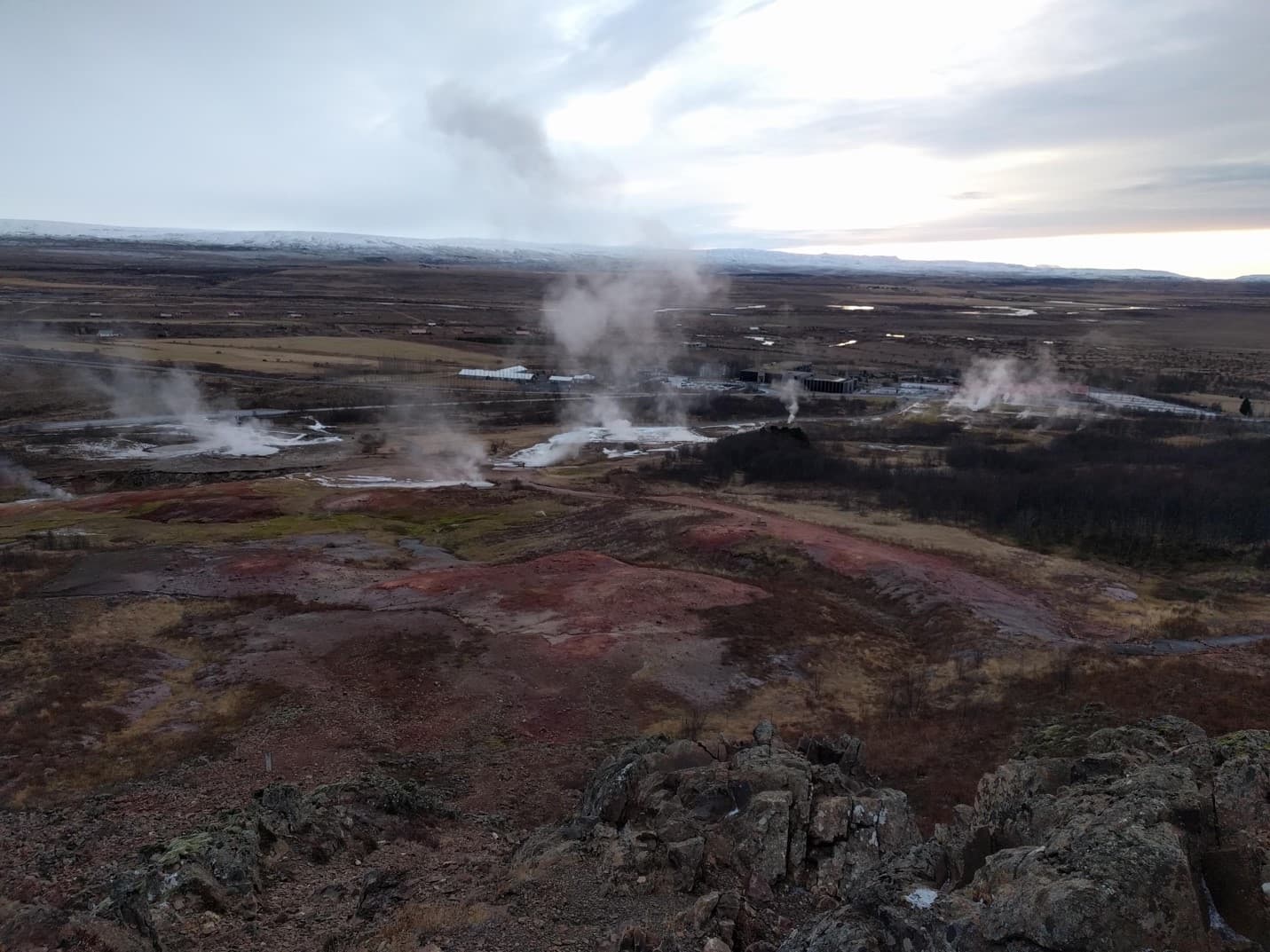 Steam and geothermal ground across Haukadalur viewed from the Laugarfell side of the Geysir area.