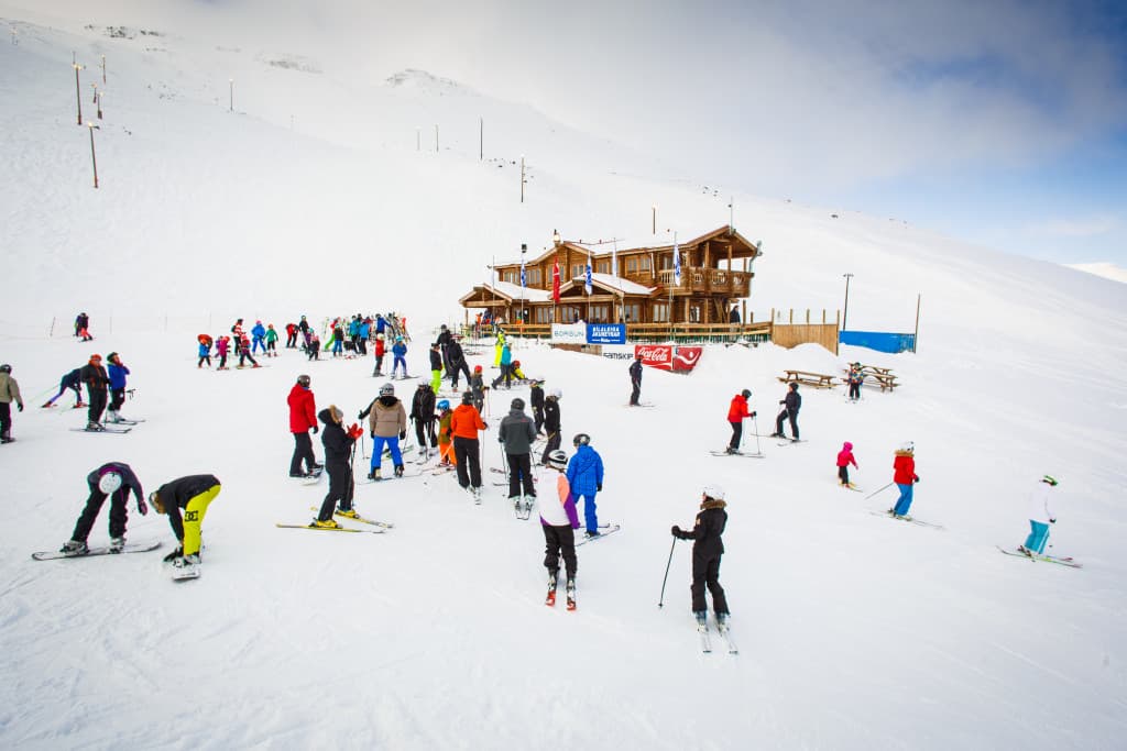 Skiers gathered near the base lodge on snowy Hlíðarfjall above Akureyri.