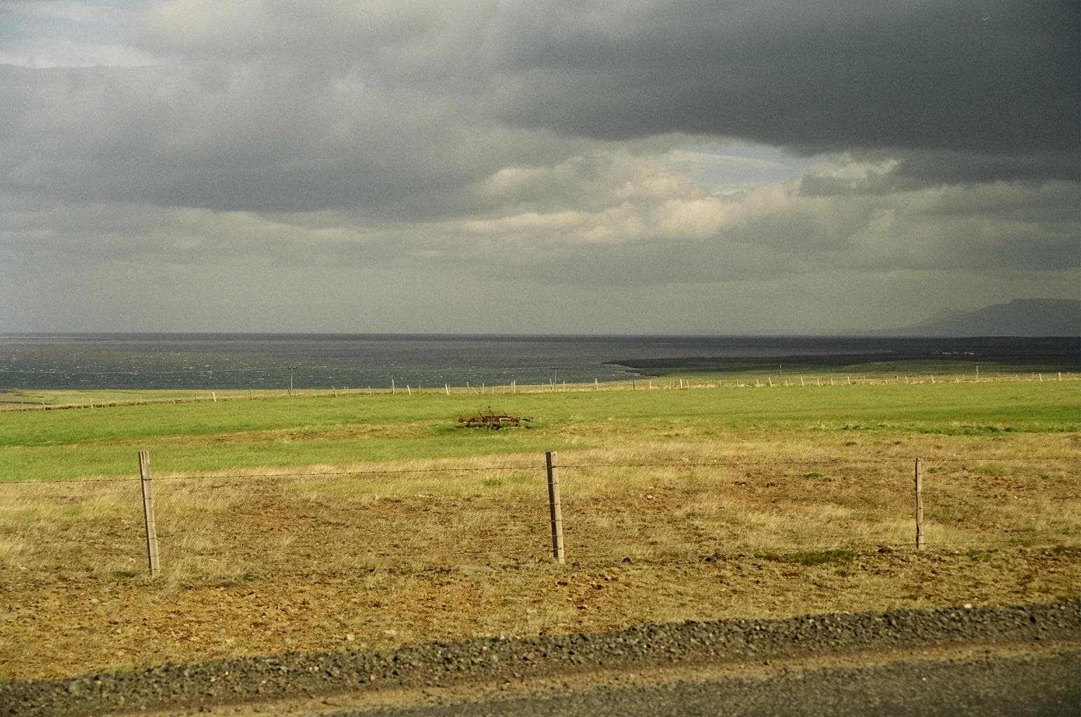 Hóp Lake seen across low farmland under heavy clouds in North Iceland.