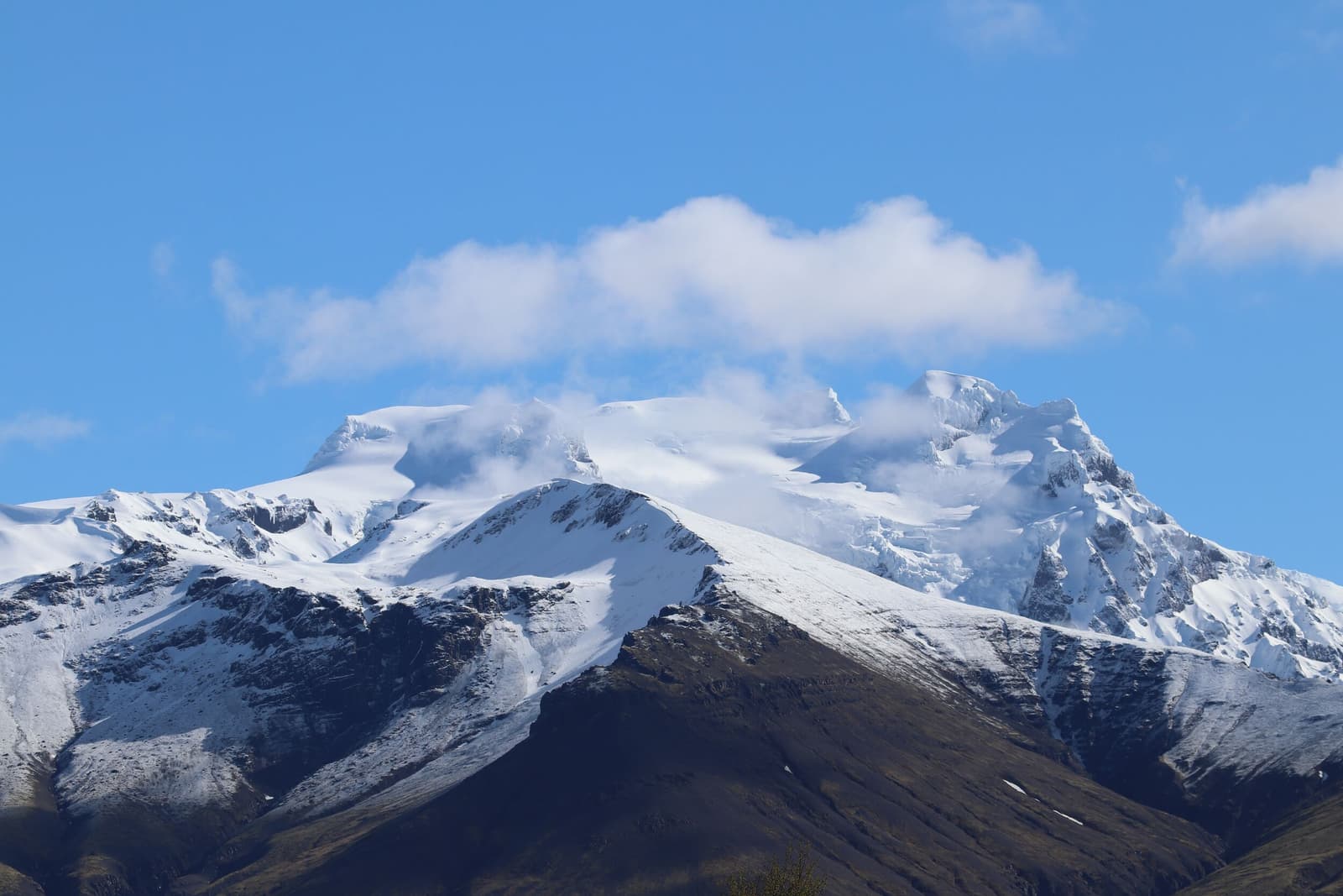 Hrútfjallstindar rising above glacier ice and dark ridges in southeast Iceland.