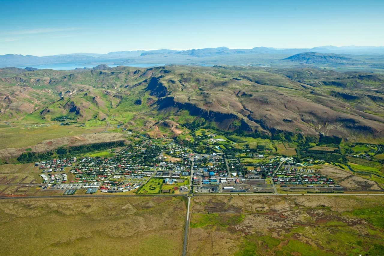 Hveragerði spread across a green valley below hills in South Iceland.