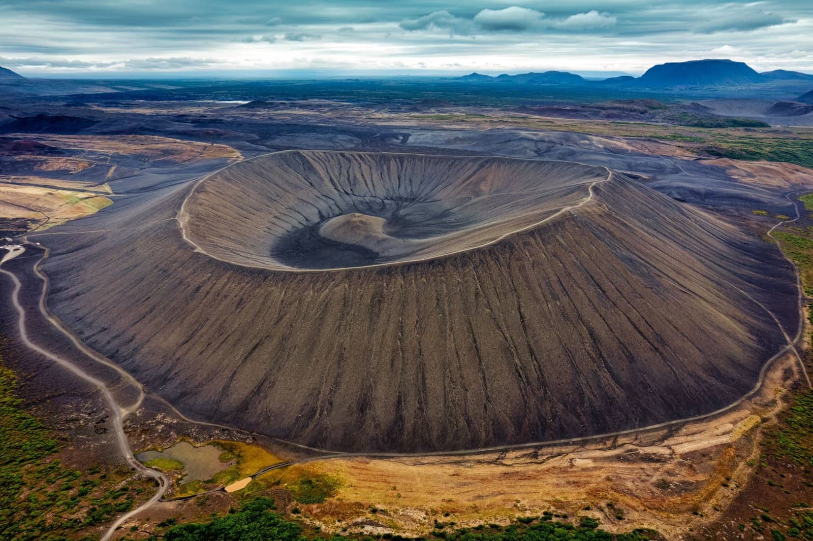 Aerial view of Hverfell crater with a circular rim path and volcanic landscape near Lake Mývatn.