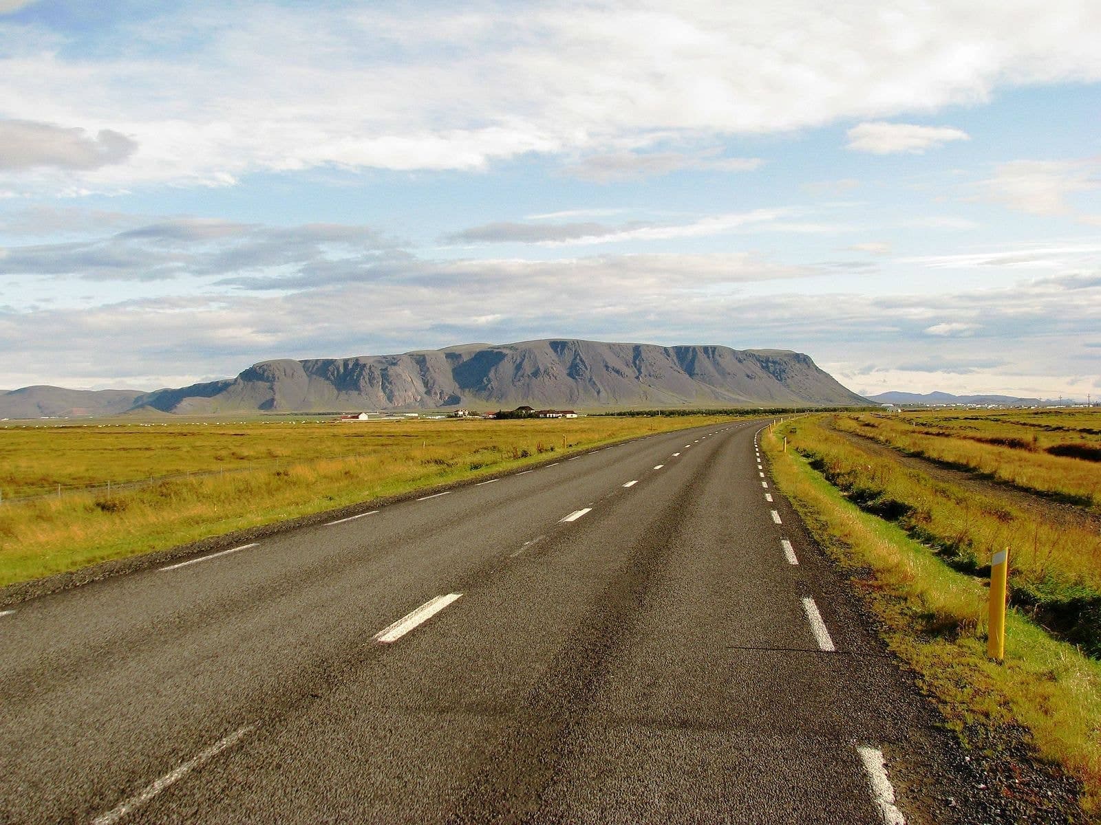 Ingólfsfjall rising above the road and low farmland near Selfoss in South Iceland.