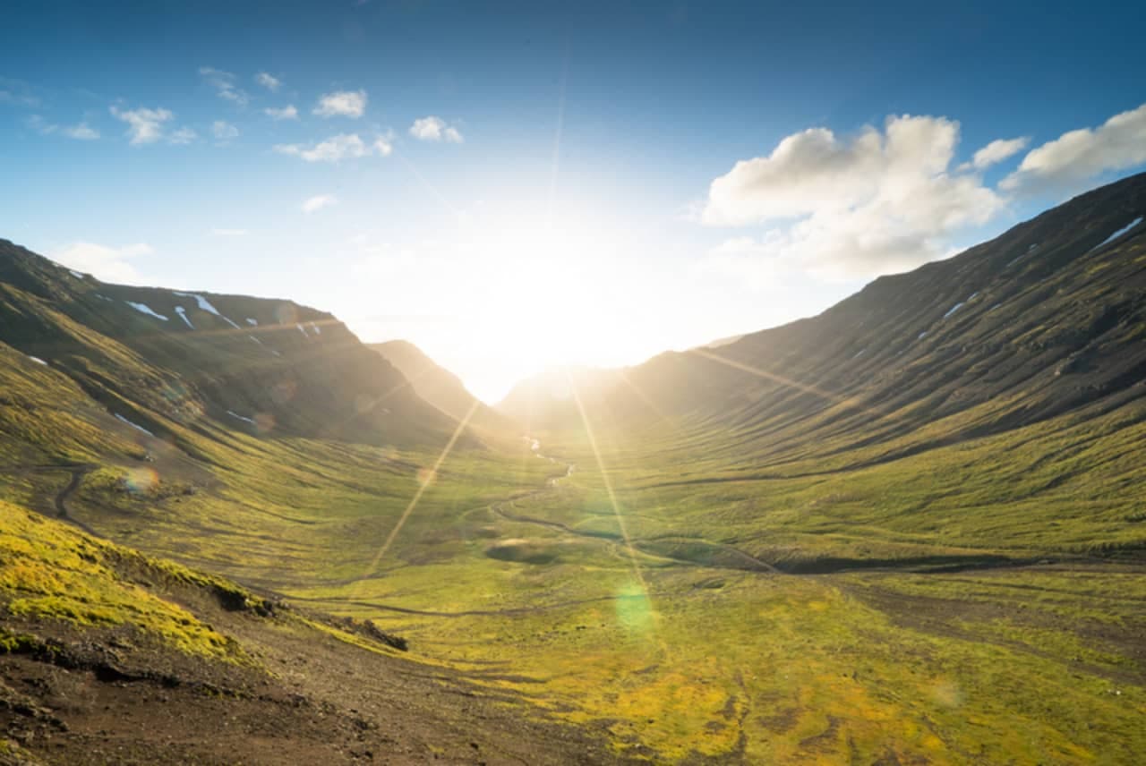 Sunlit mountain valley below Kaldbakur in the Westfjords Alps.