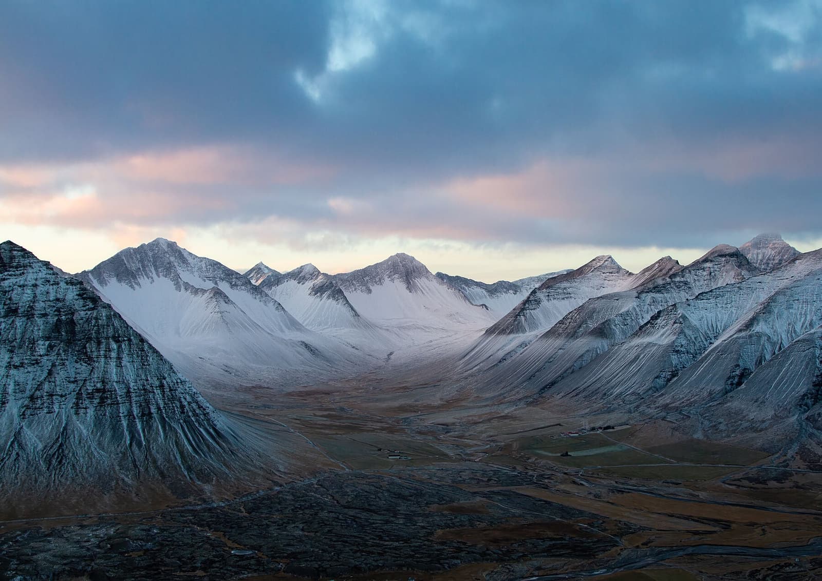 Snow-dusted mountains surrounding Kirkjubólsdalur valley in the Westfjords.