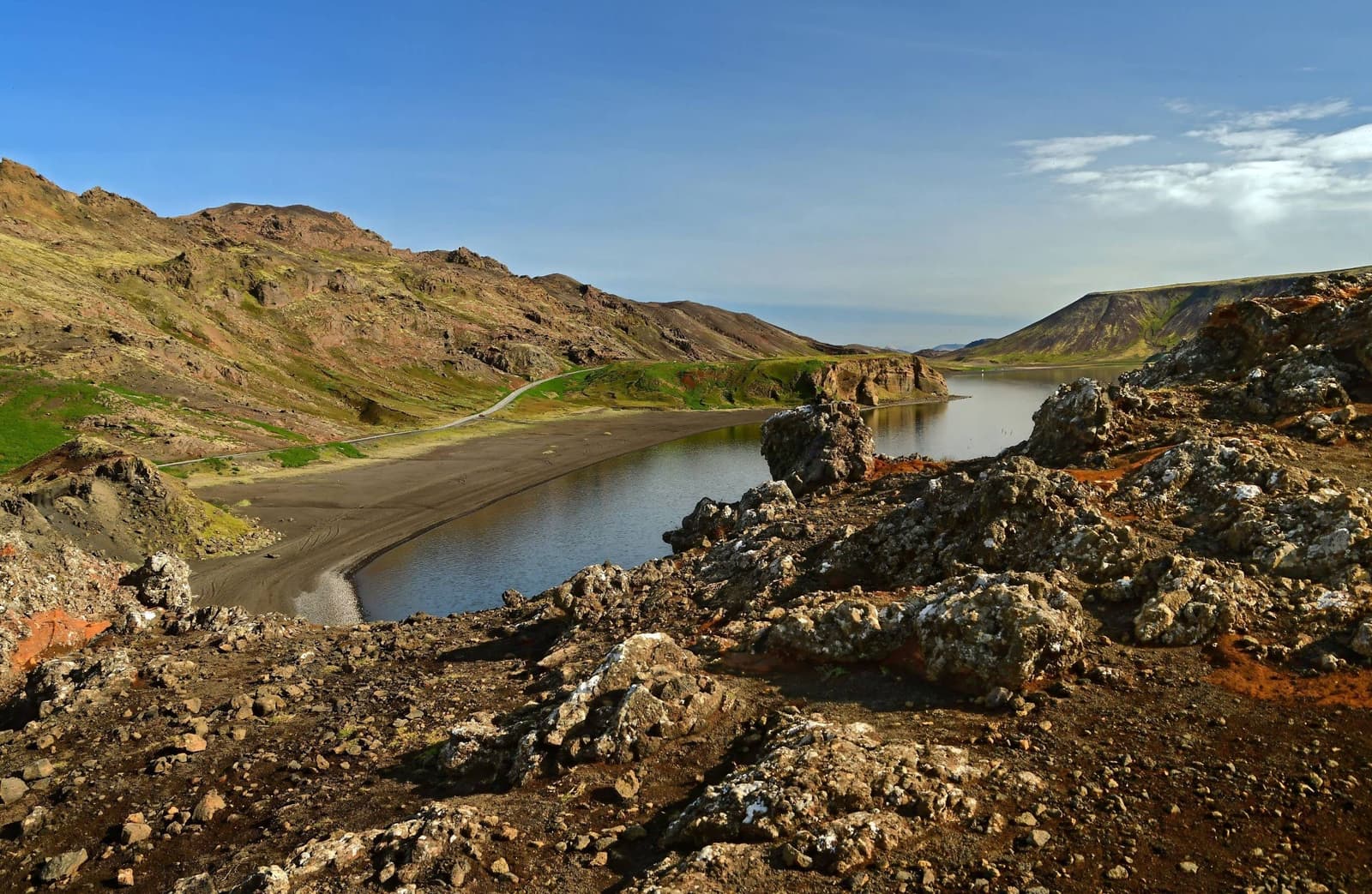 Kleifarvatn lake below volcanic hills and a shoreline road on the Reykjanes Peninsula.