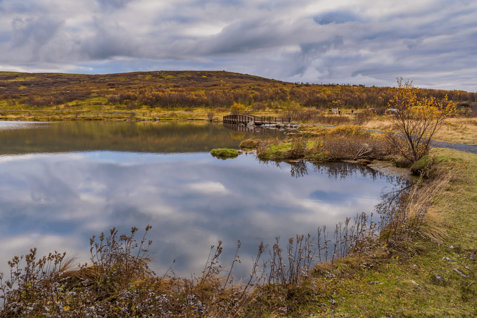 Elliðavatn lake with autumn shoreline, calm reflections, and a footpath near Reykjavík.