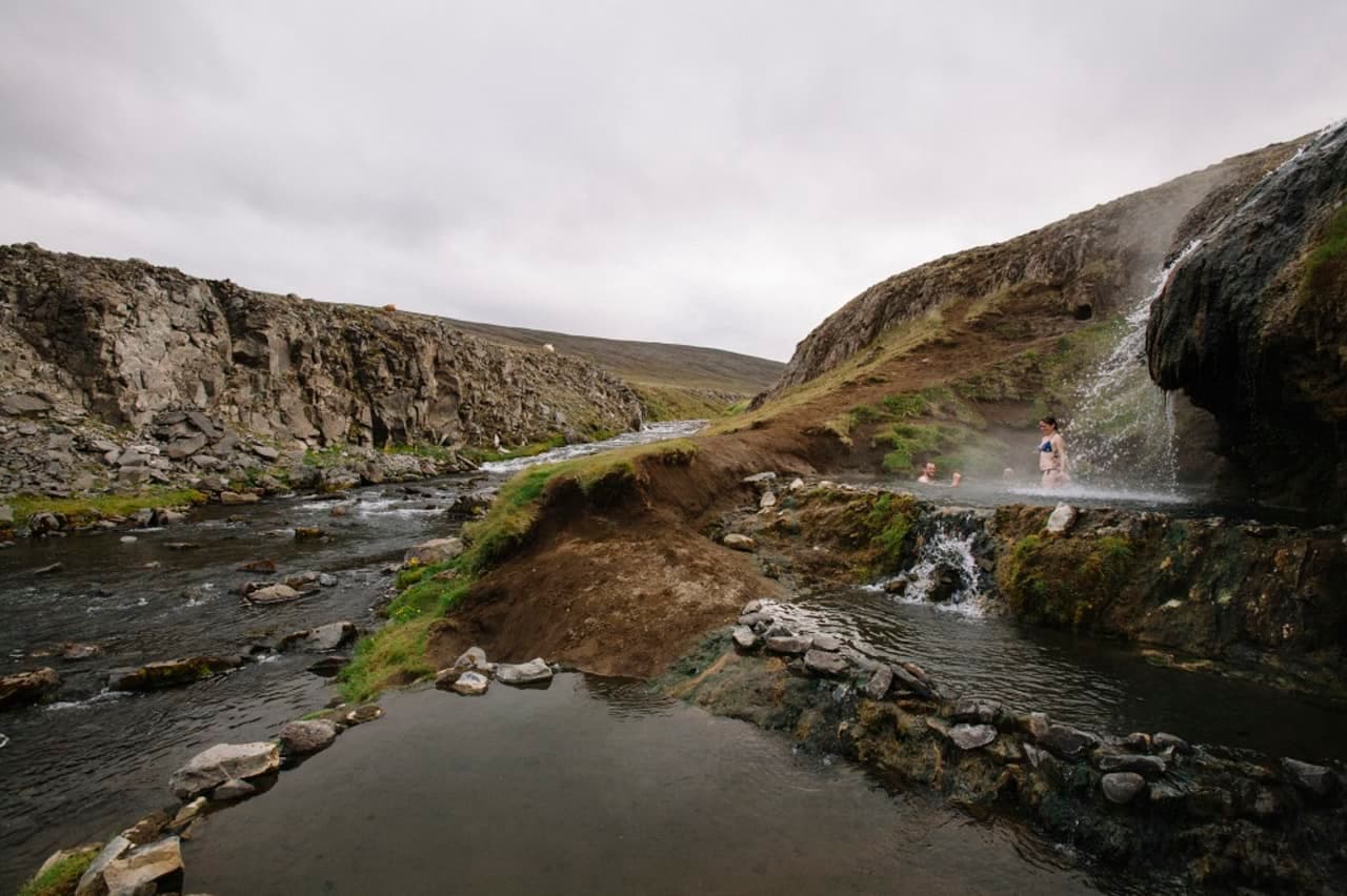 Warm waterfall and rocky river valley at Laugarvalladalur in East Iceland.
