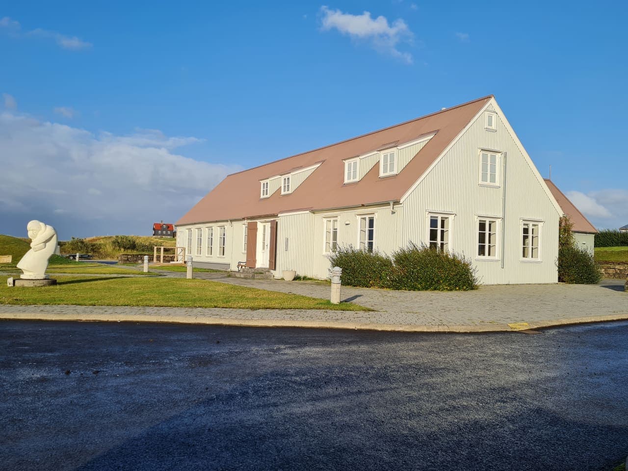 White Leifsbúð building in Búðardalur with a Leifur Eiríksson sculpture outside.