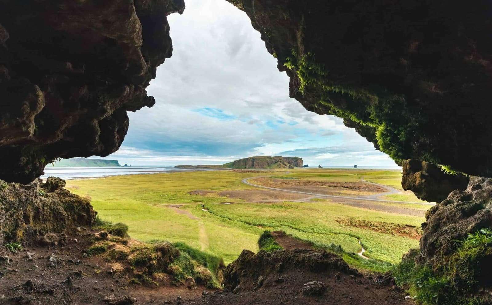 View from inside Loftsalahellir Cave toward Dyrhólaey and the South Coast plain.