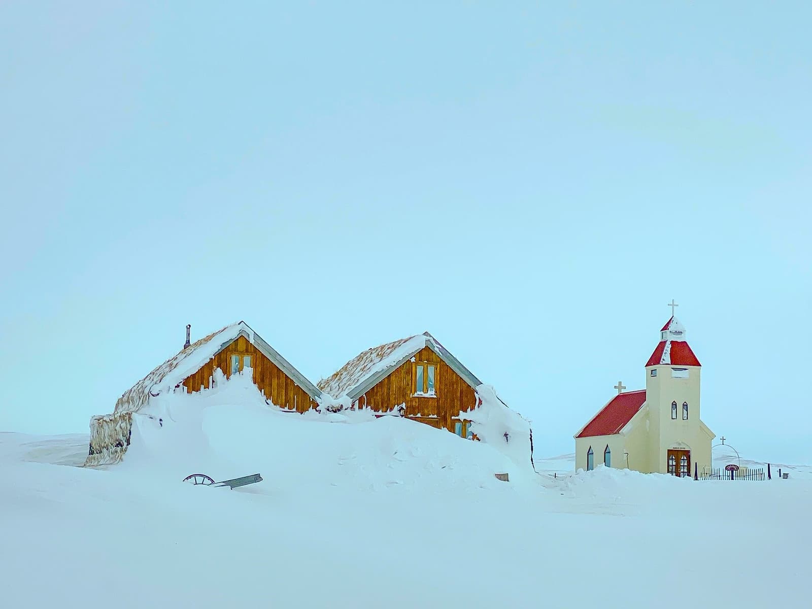 Snow-covered turf-style buildings and Möðrudalskirkja at Möðrudalur in Northeast Iceland.