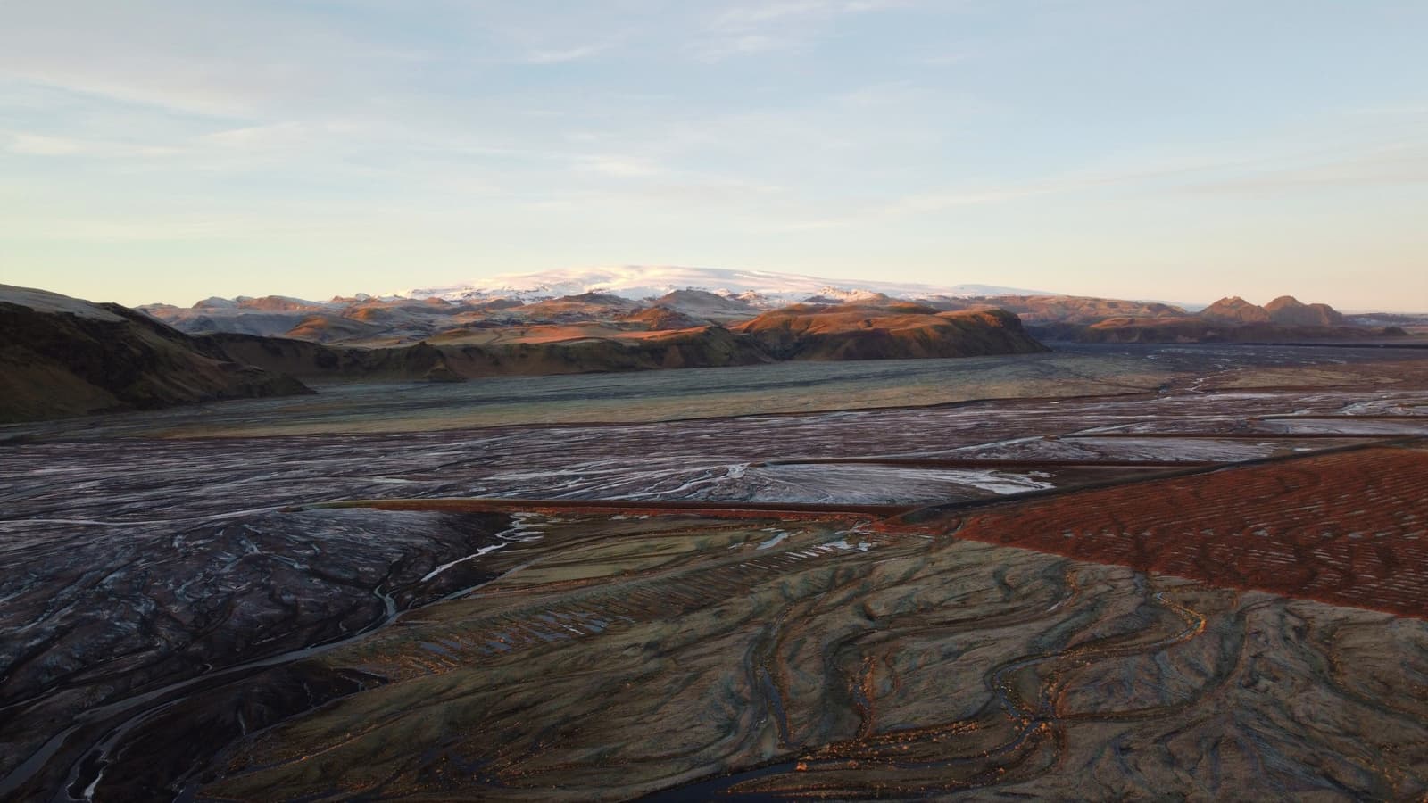Mýrdalsjökull above dark outwash plains and braided rivers near Katla in South Iceland.