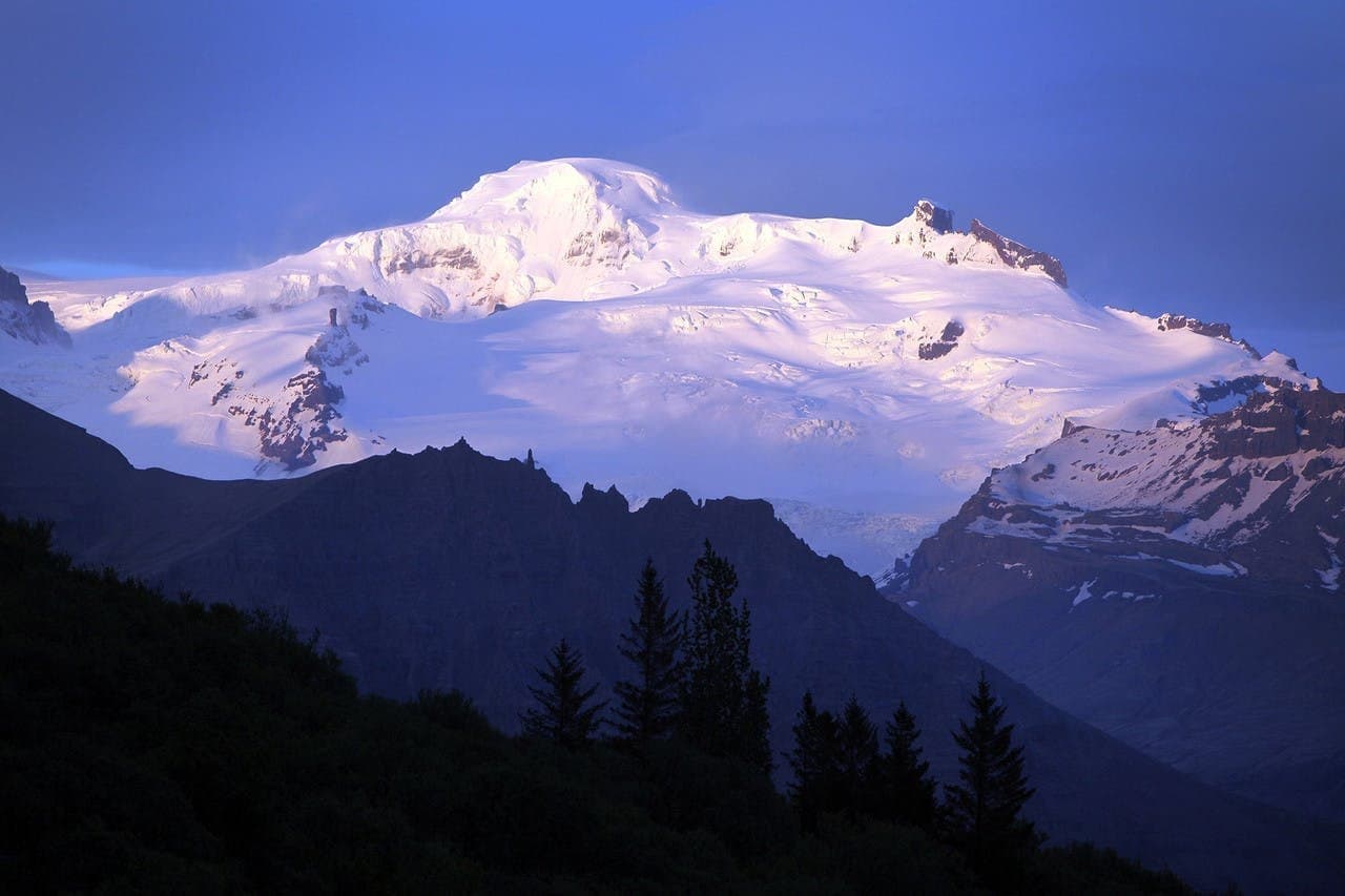 Öræfajökull and Hvannadalshnúkur glowing above shadowed ridges near Skaftafell.