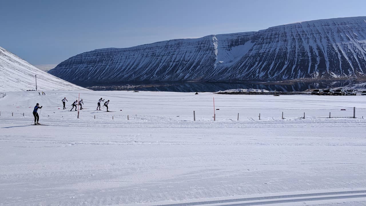 Cross-country skiers in Seljalandsdalur above Ísafjörður with steep Westfjords mountains beyond the snow.