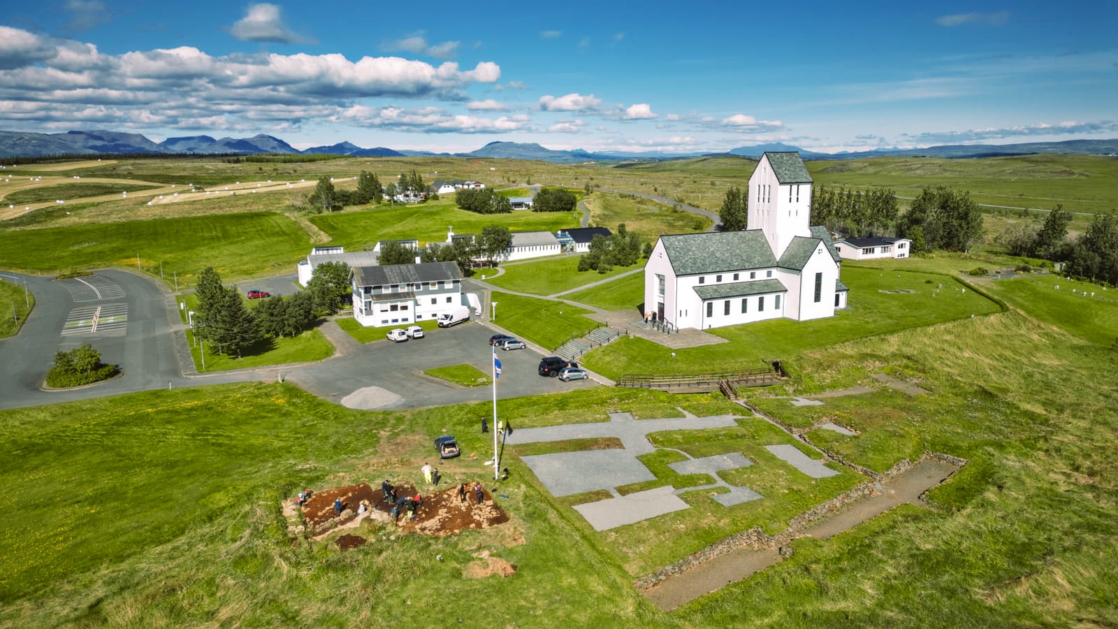 Skálholt Cathedral, parking area, pathways, and archaeology traces spread across the historic South Iceland site.