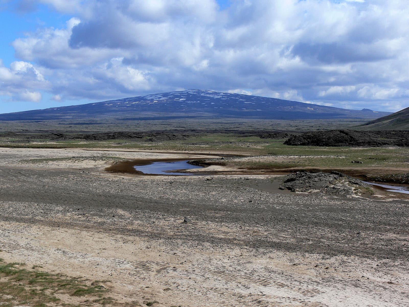 Skjaldbreiður spread across the horizon beyond rough lava flats and pale highland ground.