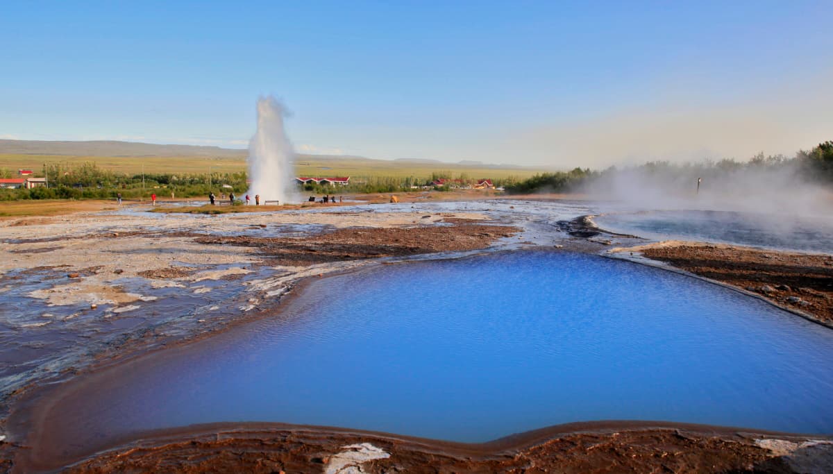 Strokkur erupting across the protected Geysir geothermal area on the Golden Circle.