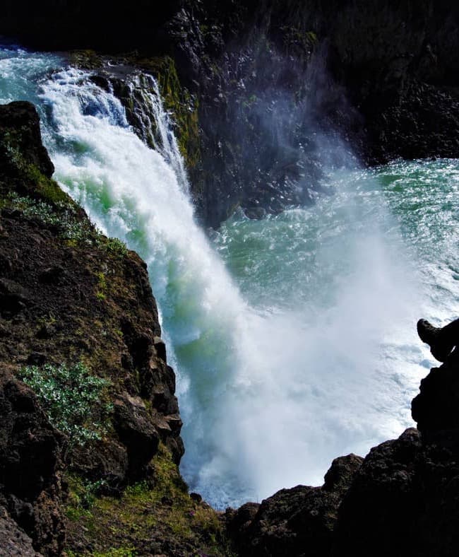 Water pouring through dark rock at Ullarfoss in North Iceland.
